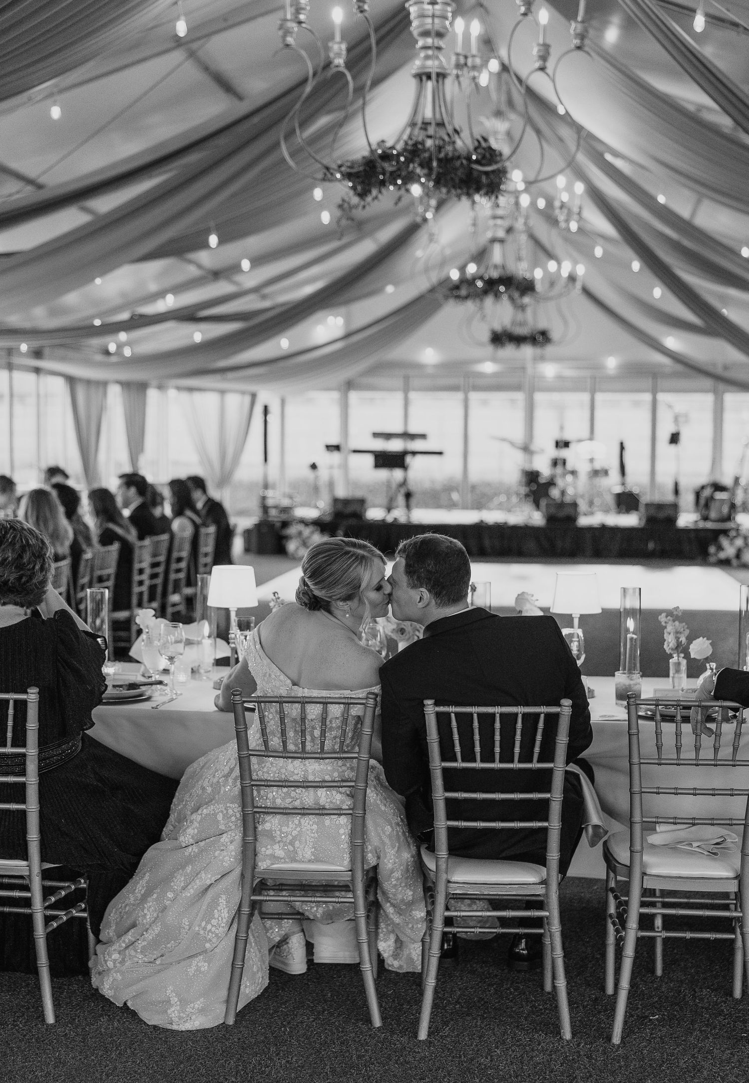 A black and white photo of an elegant tented wedding reception with chiavari chairs.