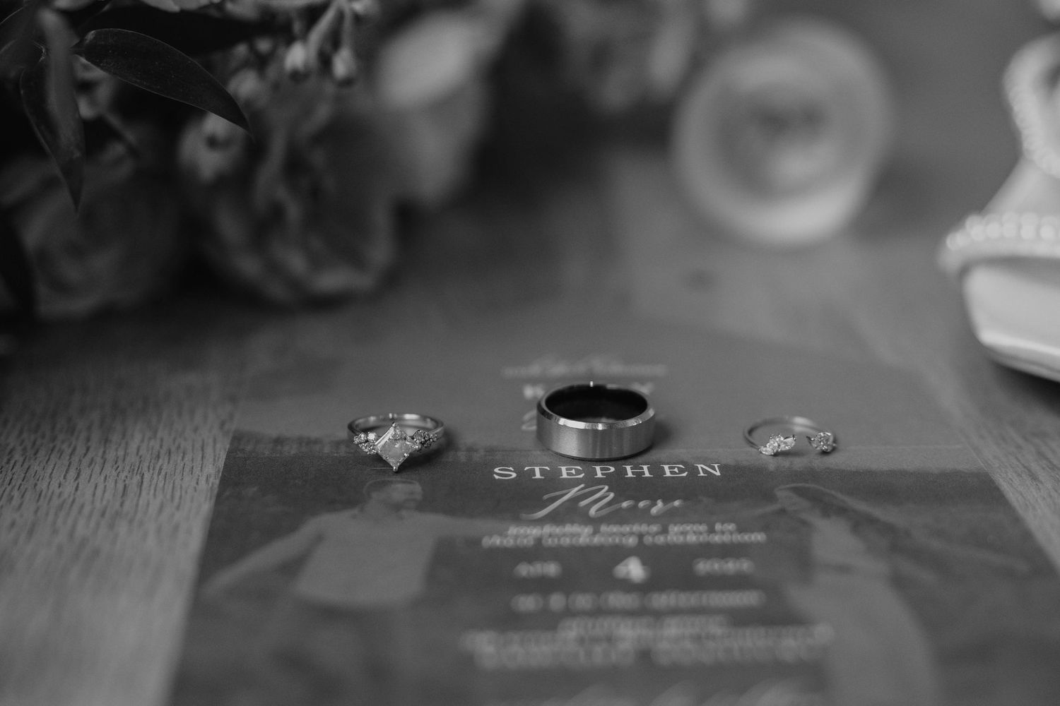 Black and white photo series of wedding rings and jewelry details arranged artistically on various surfaces.