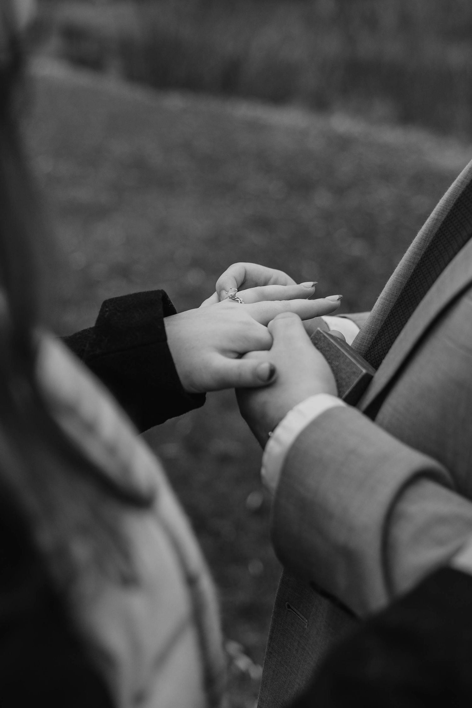Close-up black and white photo of hands playing a violin showing delicate finger movements on the strings.