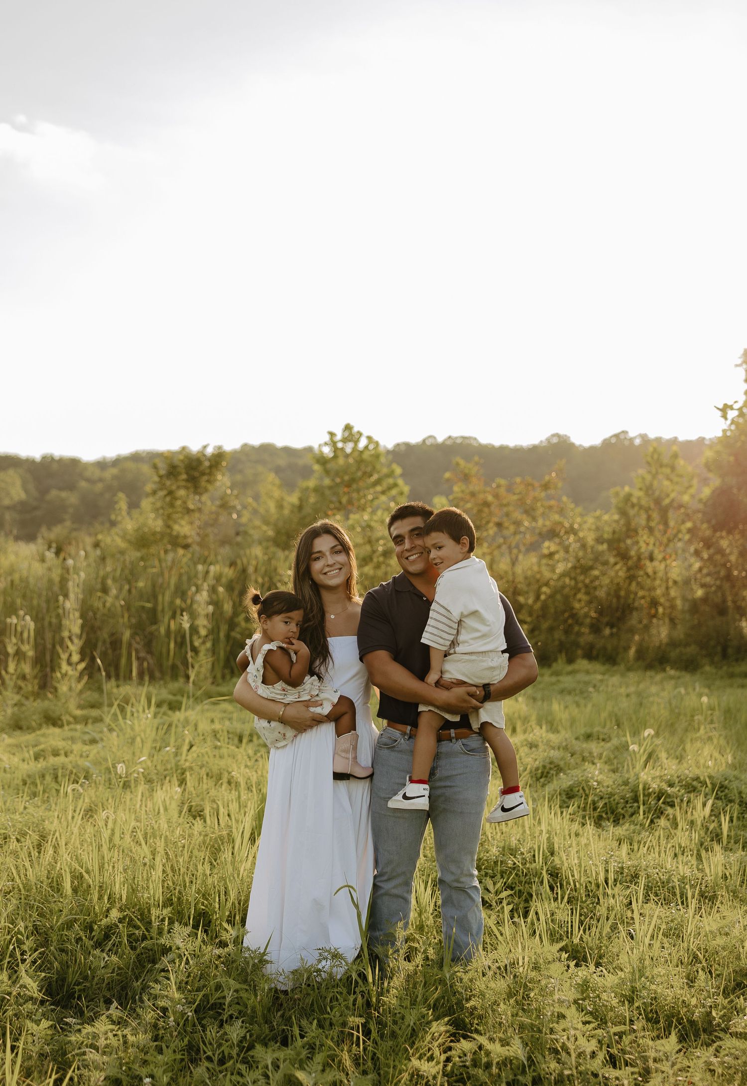 Family portrait session in a beautiful meadow during golden hour.