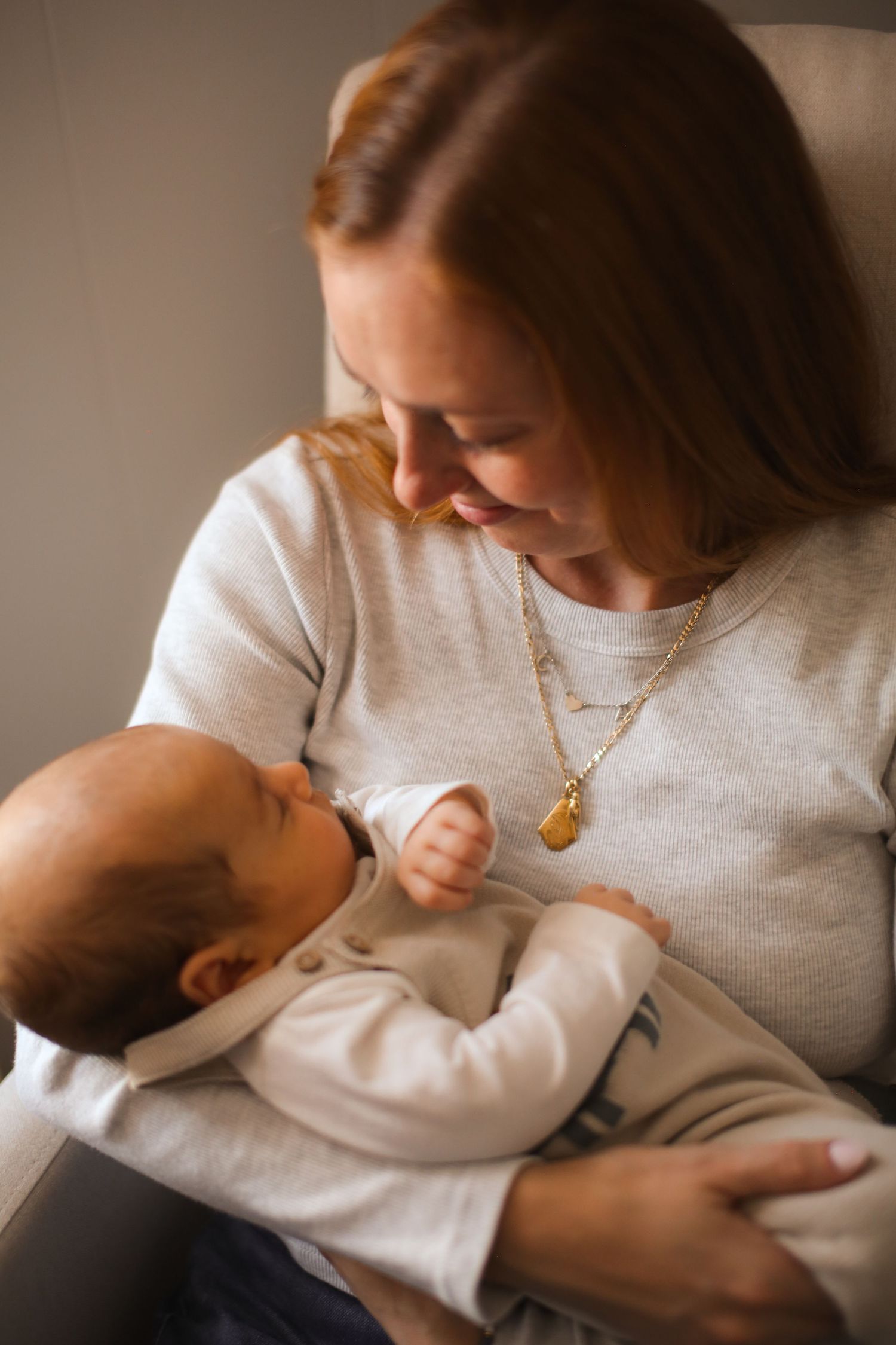 Heartwarming sequence of a parent bonding with their baby in white sweaters.