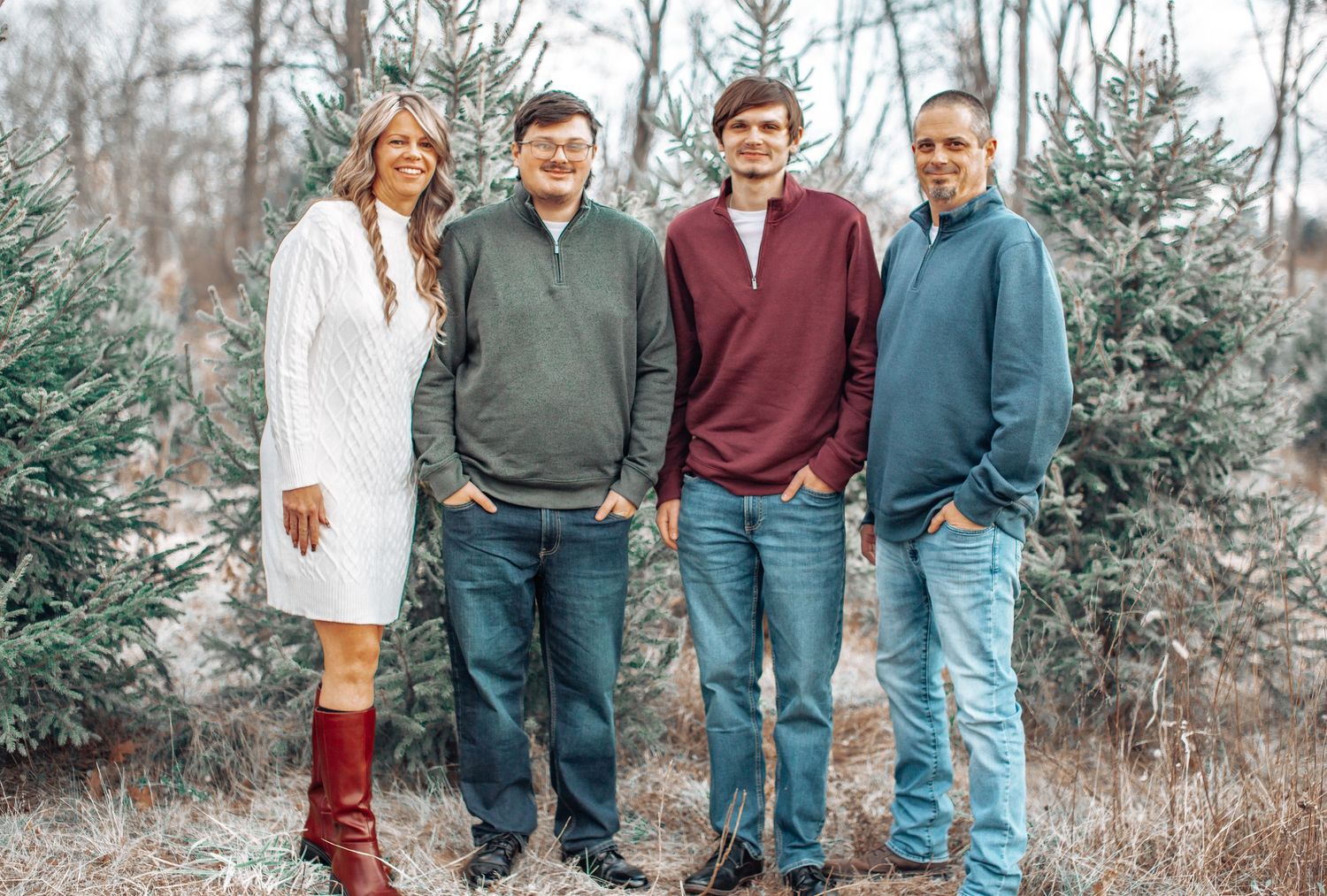 A group of people standing together outdoors in casual attire during autumn with bare trees in the background.
