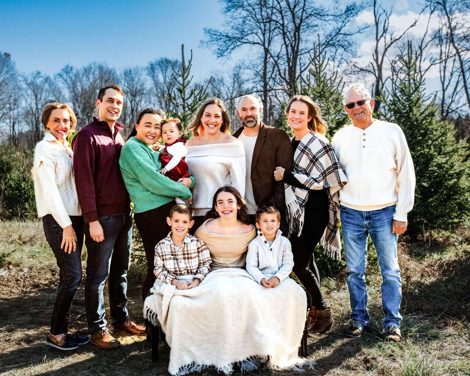 A series of outdoor family portrait photographs taken in a natural setting with trees and sunlight.