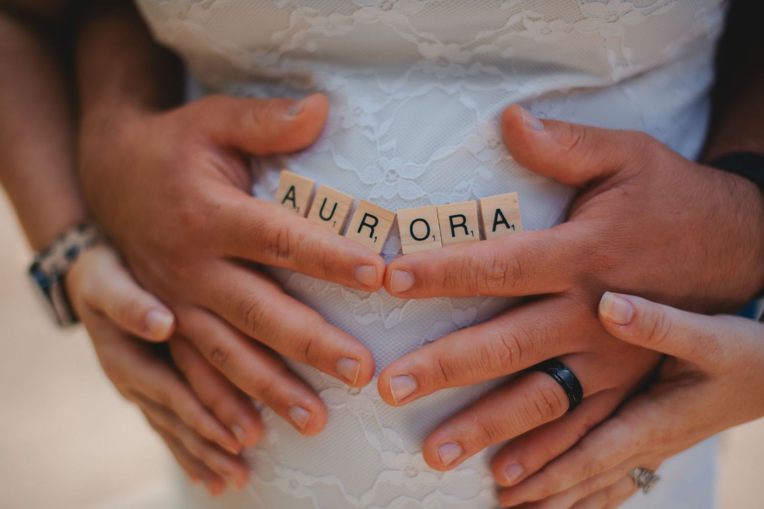 Close-up shots of hands resting on a pregnant belly with rings visible.