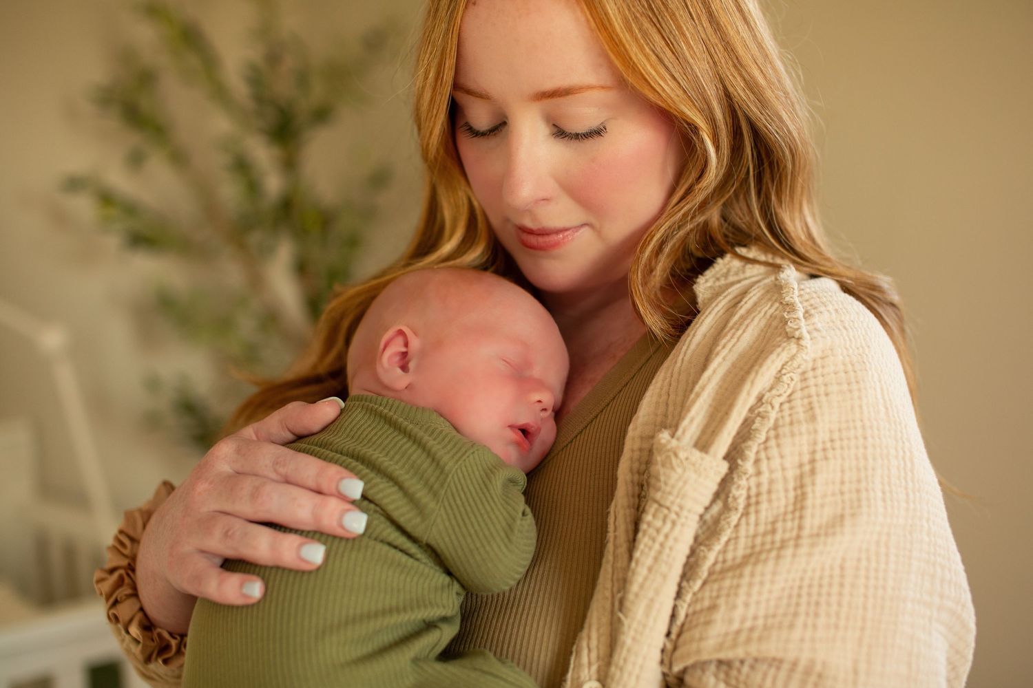 Tender family moment in warm earth tones with olive green accents.