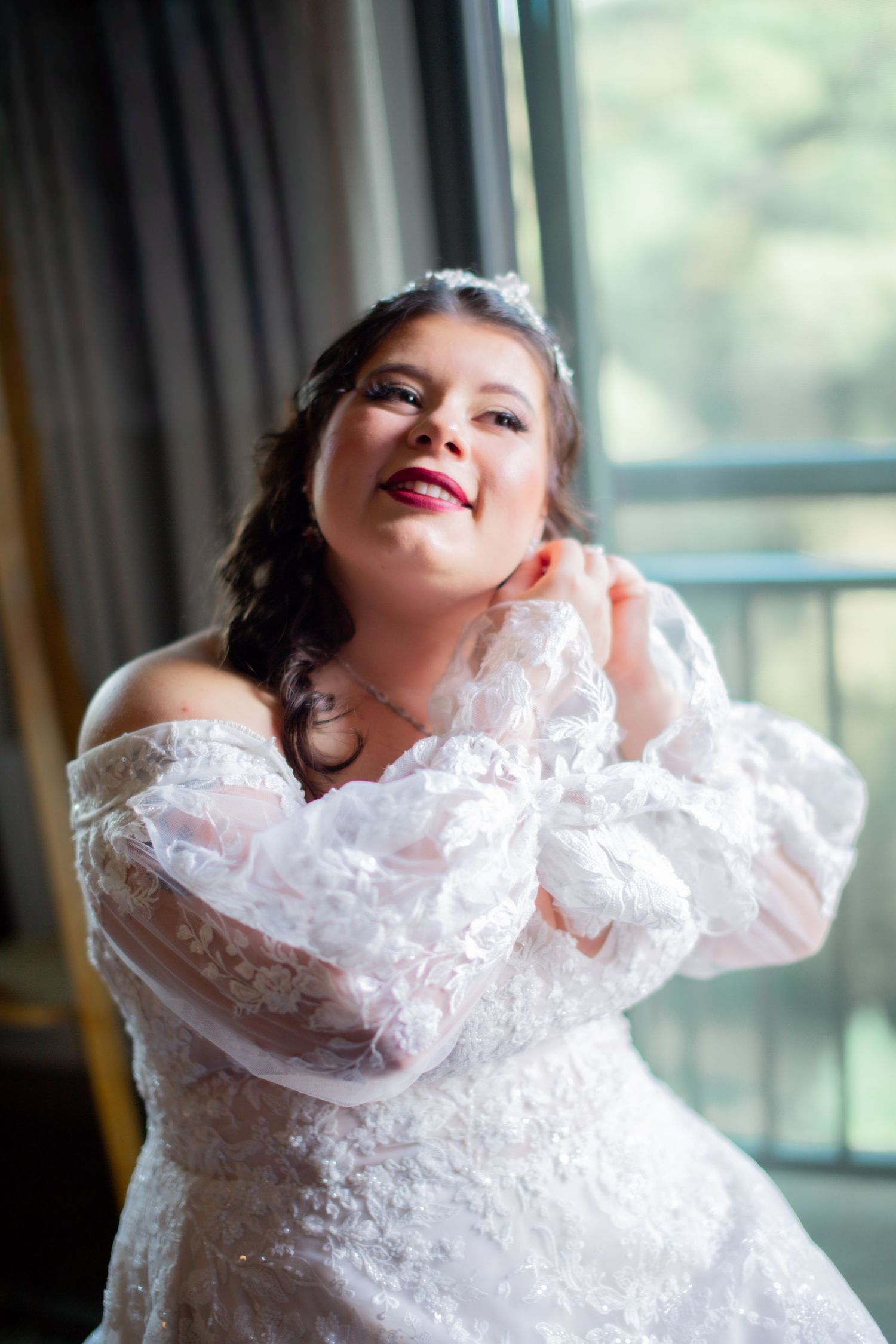 A series of four photos showing a child wrapped in delicate white lace fabric posing artistically by a window.
