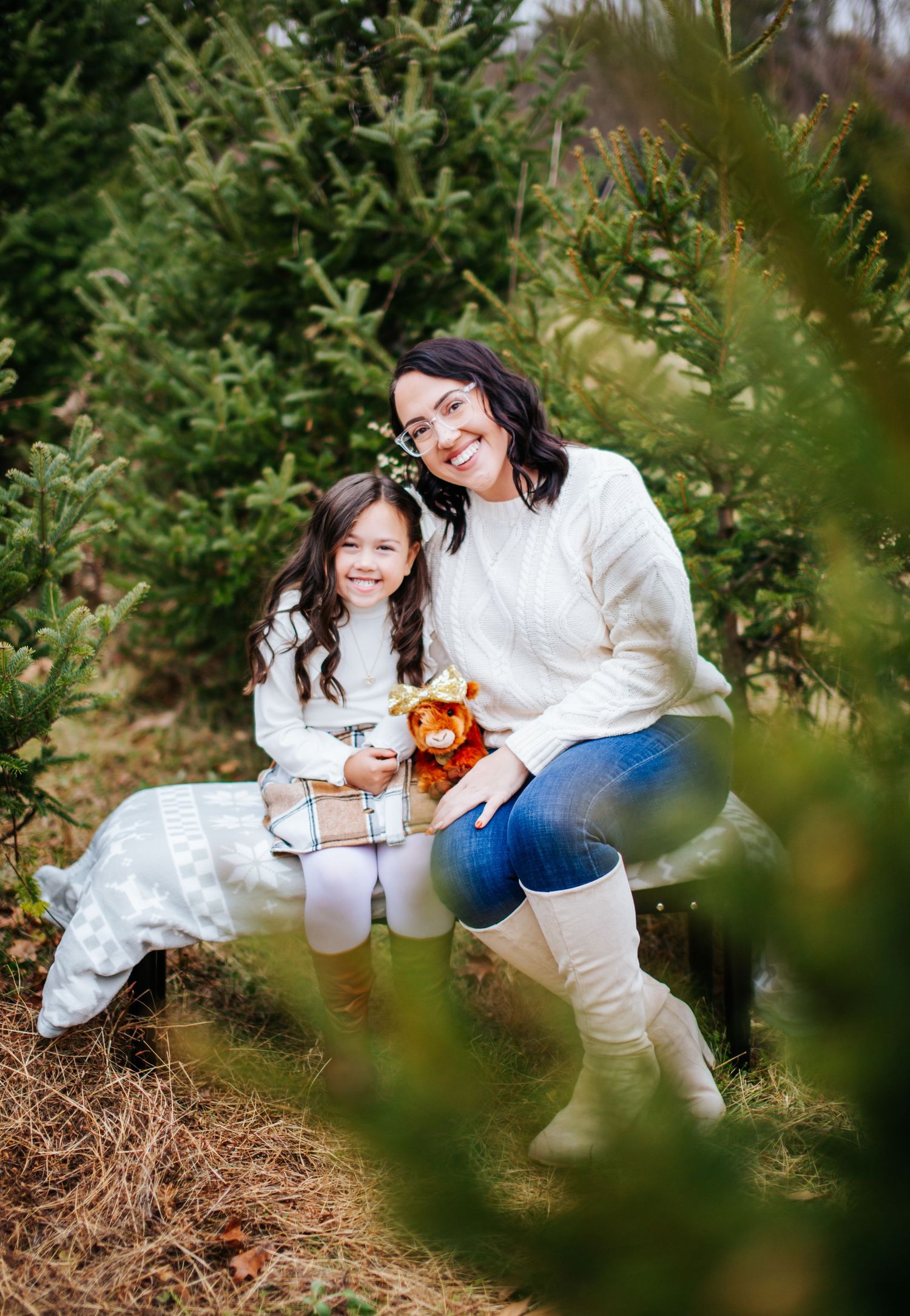 A magical Christmas moment captured in a series of photos among evergreen trees with a glowing lantern.