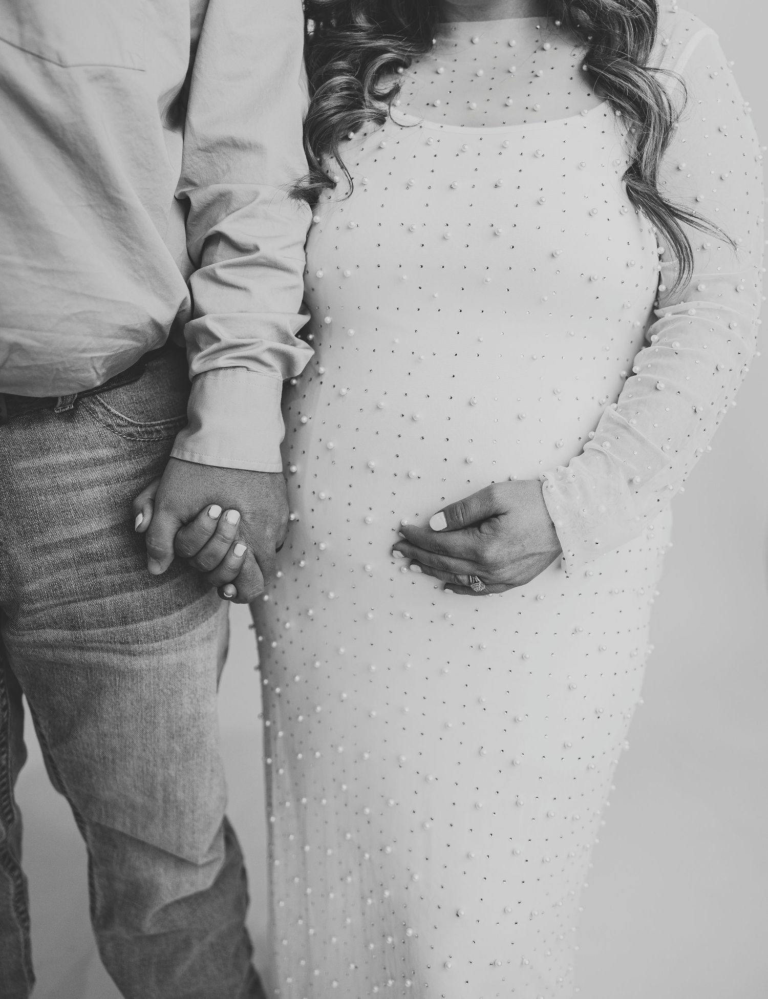 Black and white image series showing two figures embracing against a dotted wall in a romantic sequence of poses.