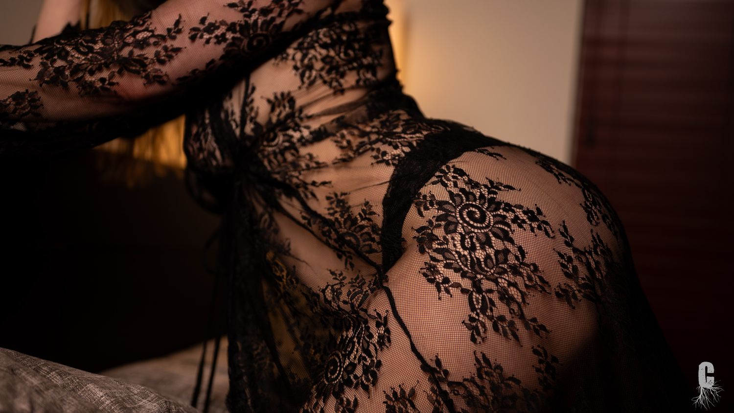 A boudoir model draped in lace showing off her curves