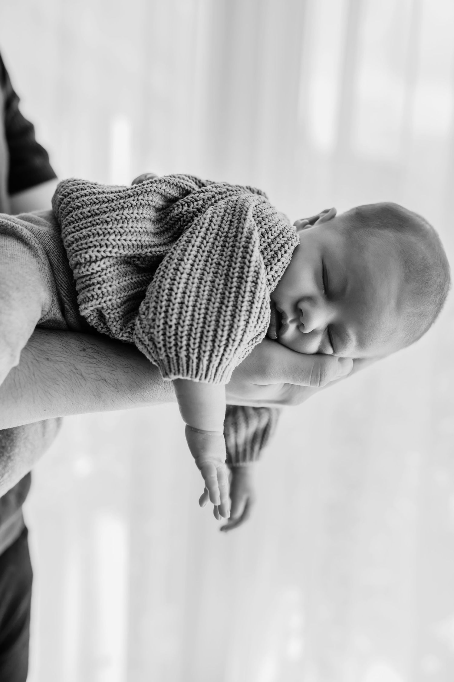 Black and white photo series showing a sleeping baby wearing a knit hat in different poses against a white background.