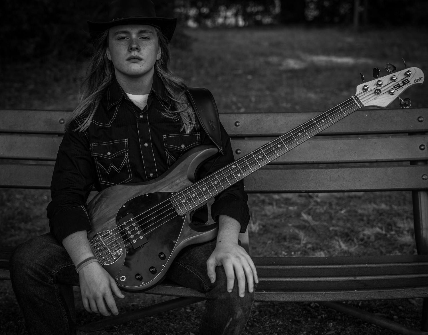 Moody black and white portrait of a western-style band artist with his instrument — KN KROMATIC Photography Houston portrait photographer