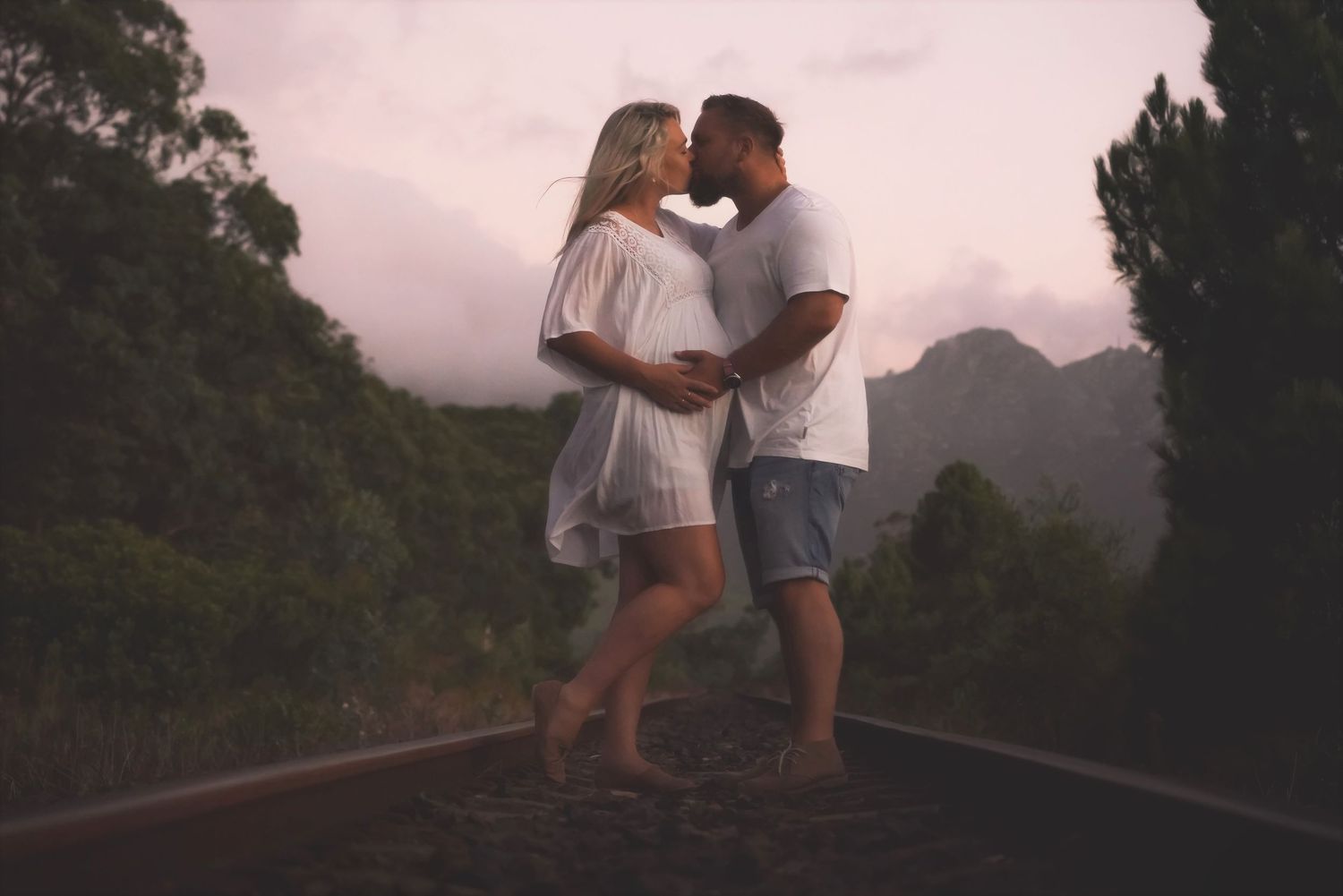 Couple embracing on a path at dusk with mountains behind in Sir Lowrys Pass