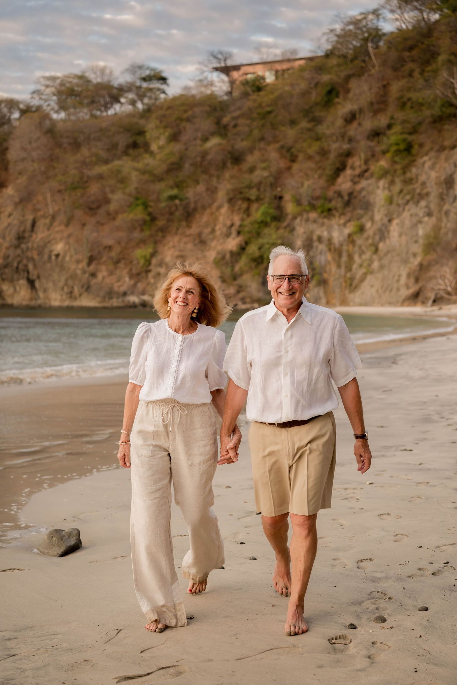 Couple walking together on the beach during a family vacation photography session in Costa Rica.