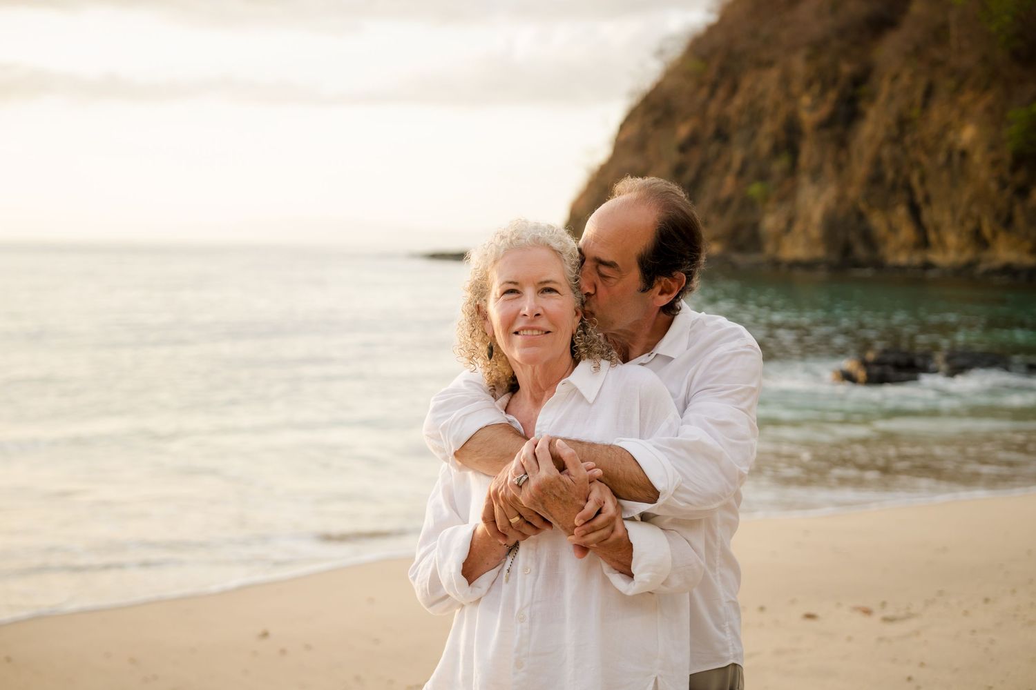 Grandparents embracing on the beach during a family vacation photography session at Four Seasons Peninsula Papagayo, Costa Rica.