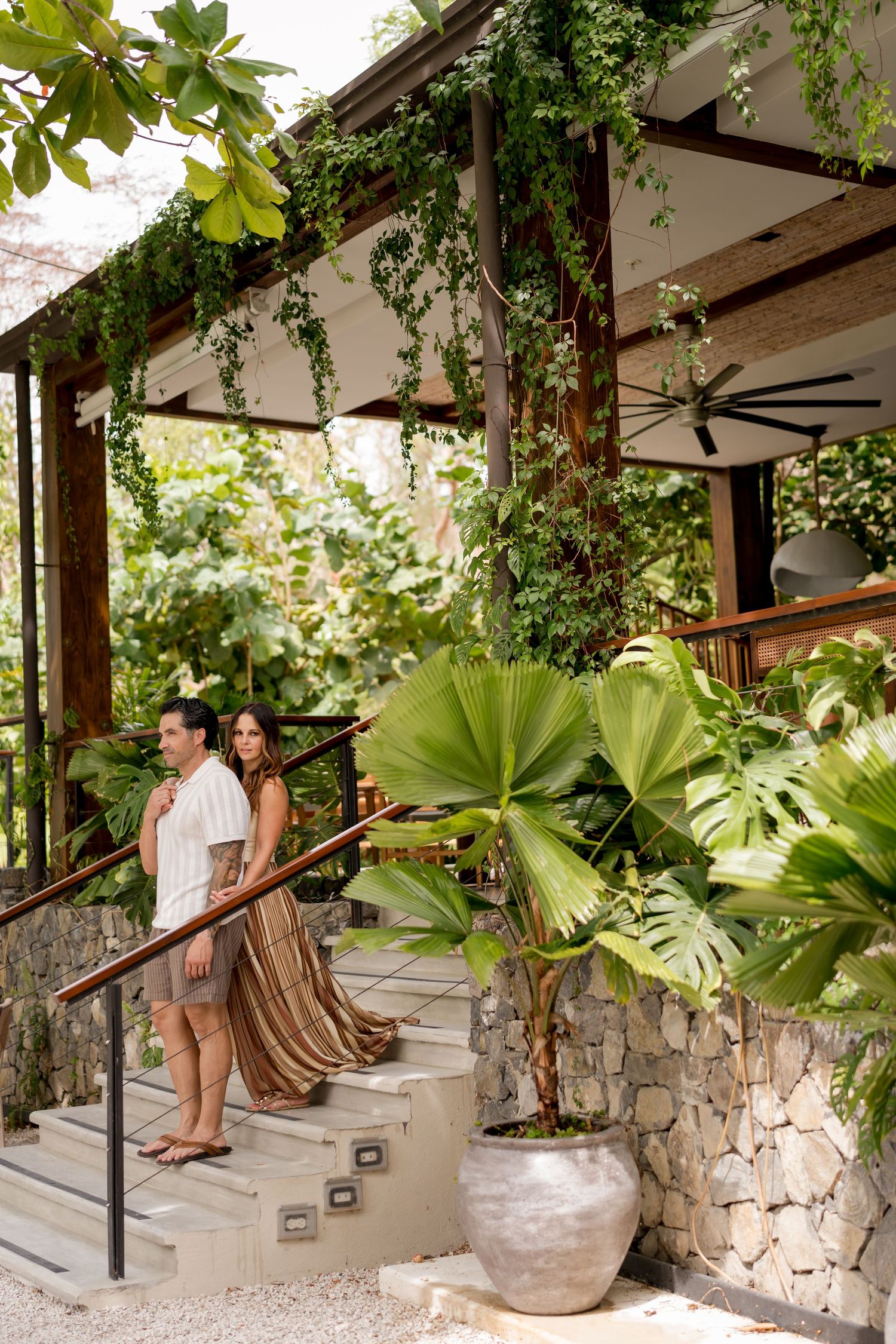 Couple walking through tropical gardens during a romantic photography session at Andaz Peninsula Papagayo in Costa Rica.