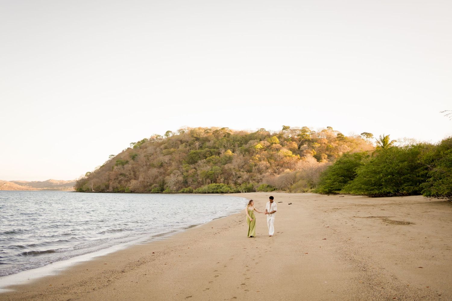 Engaged couple walking along the beach during a sunset photography session in Peninsula Papagayo, Costa Rica.