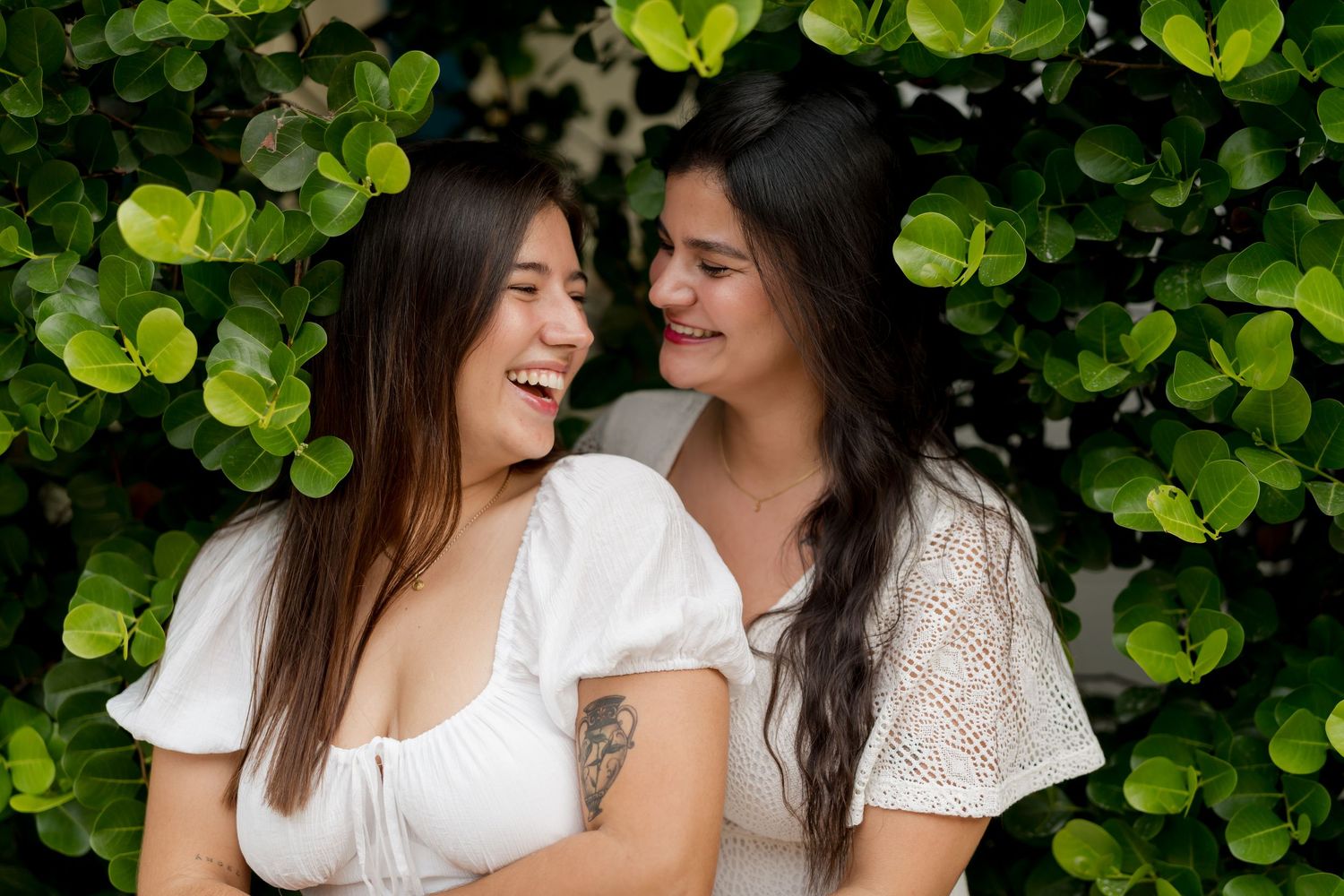 Couple laughing together during a romantic portrait session surrounded by tropical greenery at Playa Conchal, Costa Rica.