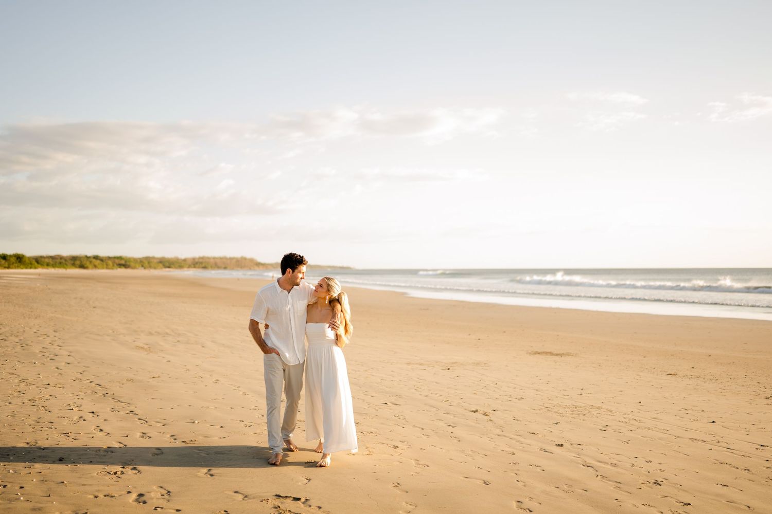 Couple embracing on the beach during a romantic photography session at Hacienda Pinilla, Costa Rica.