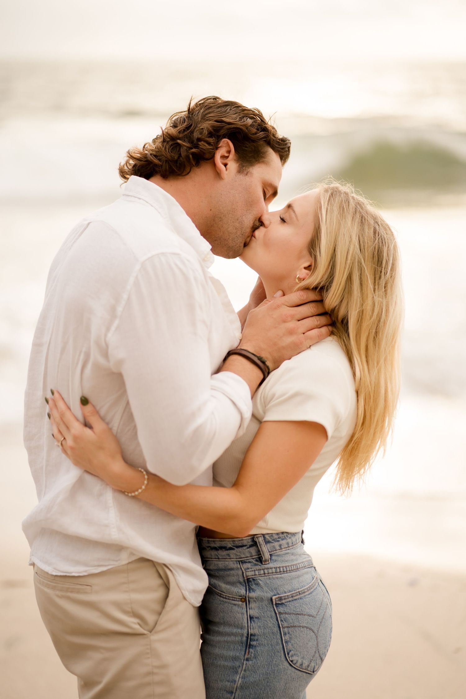 Couple kissing by the ocean during a romantic golden hour photography session at Flamingo Beach in Guanacaste, Costa Rica.