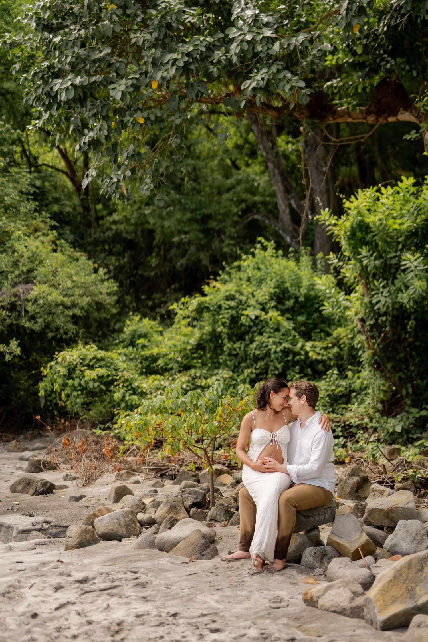 Expecting couple photographed together in a natural tropical setting at Nekajui, a Ritz-Carlton Reserve in Costa Rica.