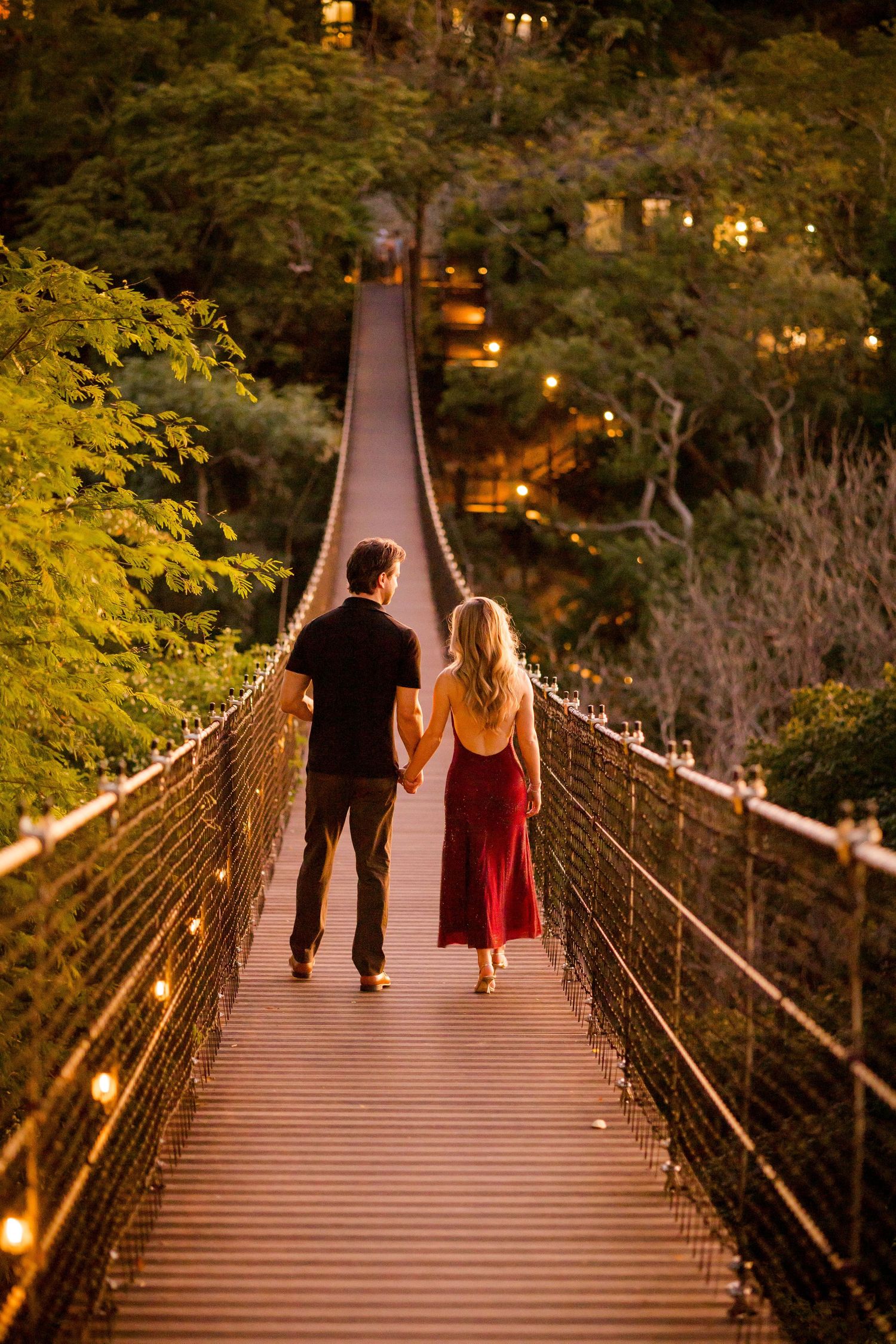 Engaged couple walking across a suspension bridge at Nekajui, a Ritz-Carlton Reserve in Costa Rica.