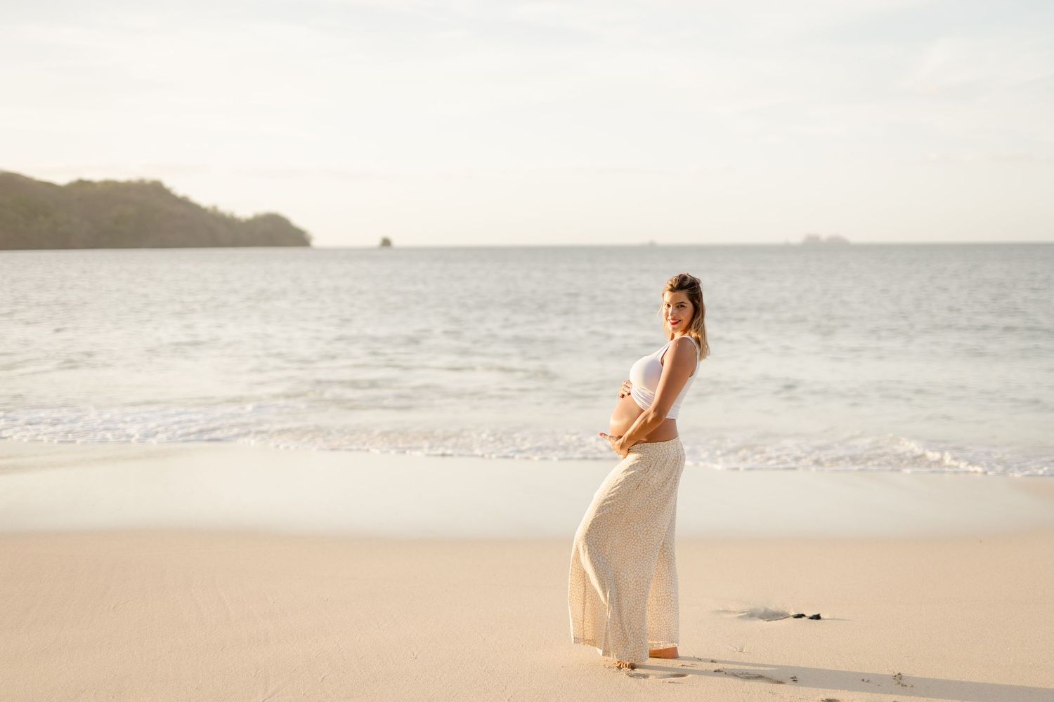 Expecting mother photographed by the Pacific Ocean during golden hour in Guanacaste, Costa Rica.
