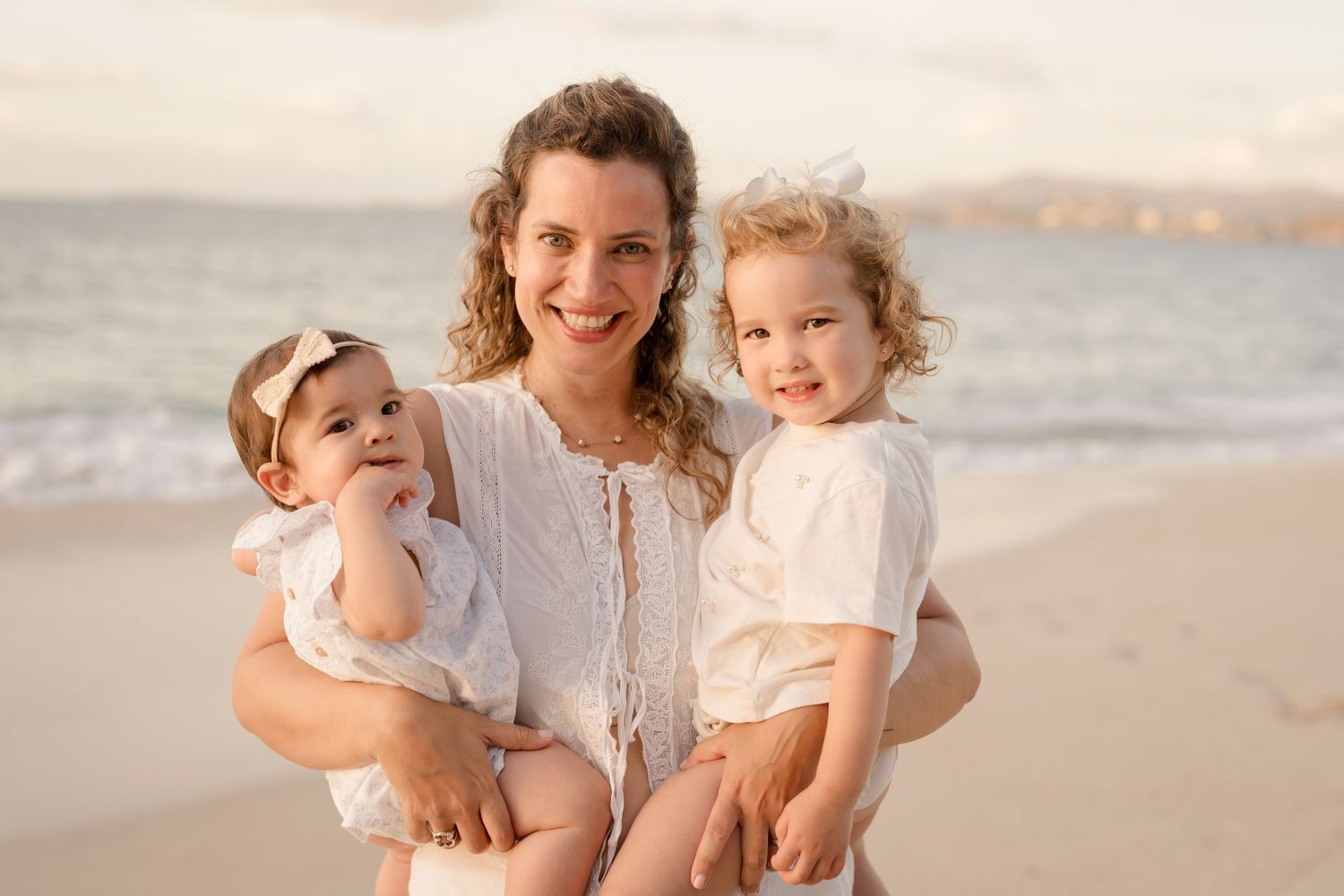 Mother holding her children during a natural family photography session on Playa Conchal in Costa Rica.