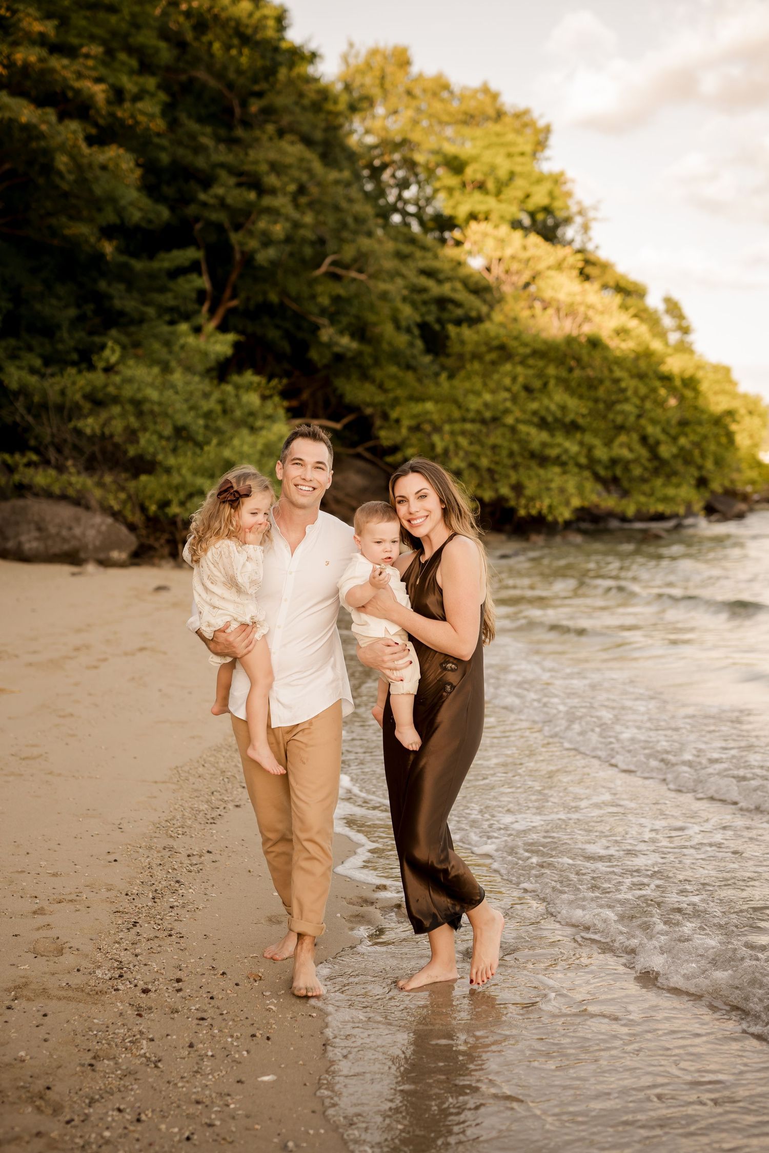 Parents and daughters walking together along a tropical beach during a family photography session in Costa Rica.
