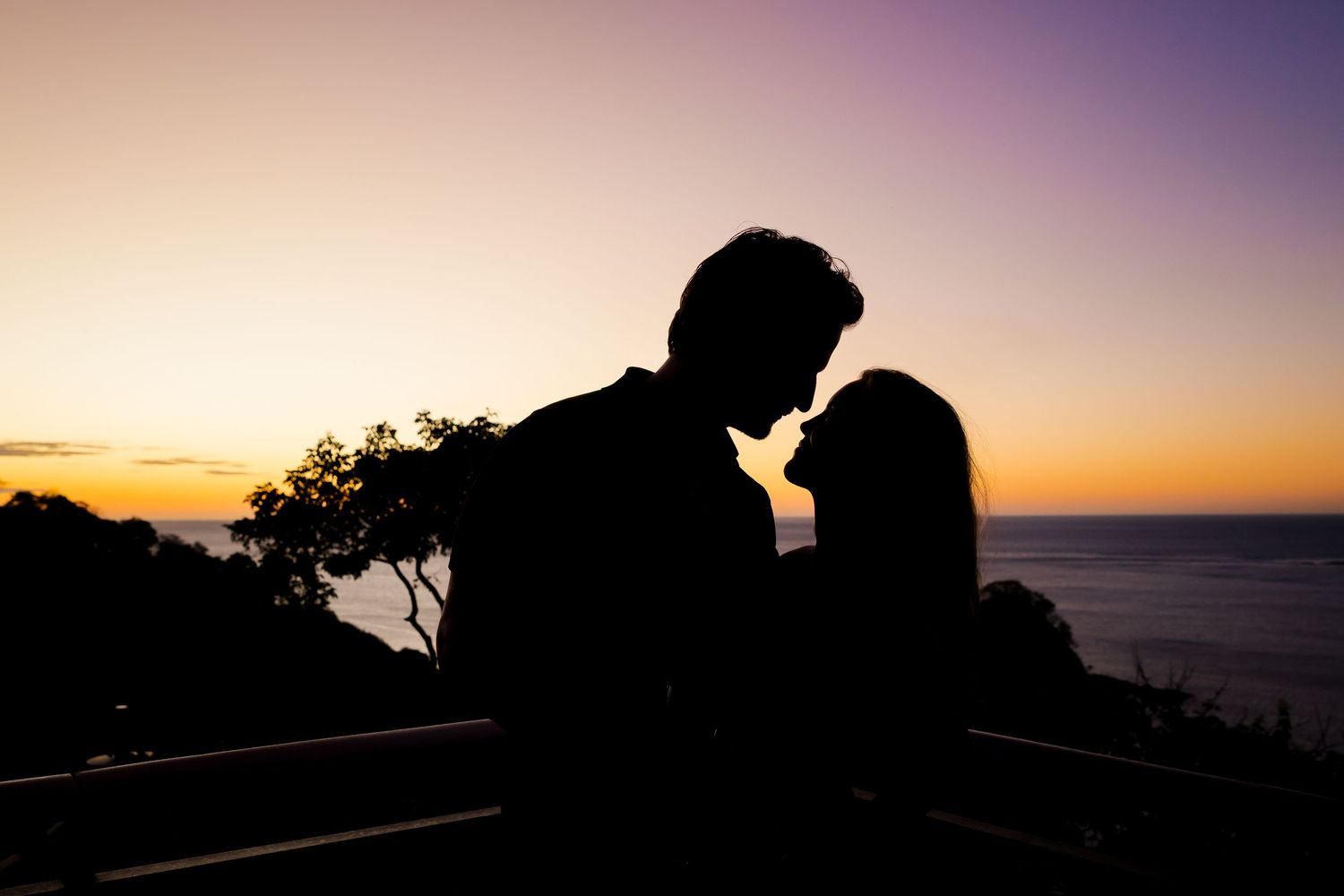 Couple embracing in silhouette at sunset during a romantic photography session in Costa Rica.