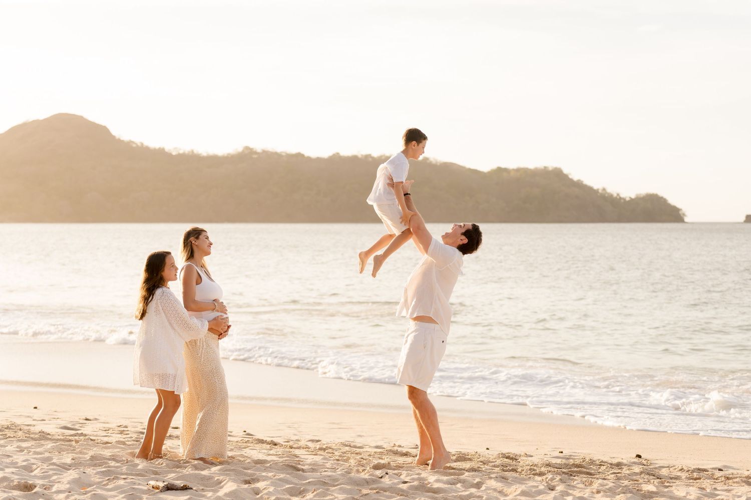 Family running together along Playa Conchal during a warm Costa Rica sunset photography session.
