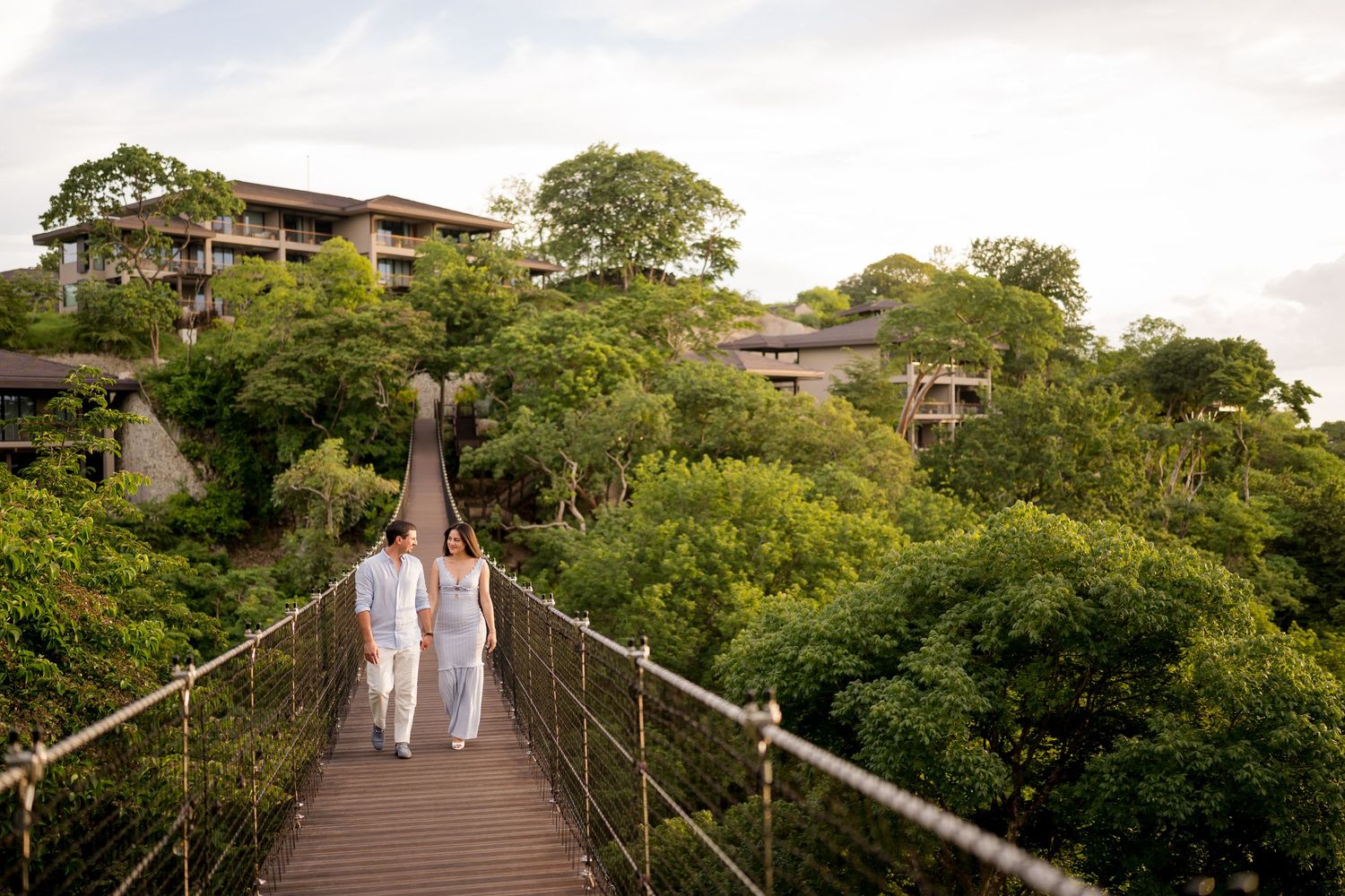 Couple walking across a suspension bridge during a photography session at Nekajui, a Ritz-Carlton Reserve in Costa Rica.