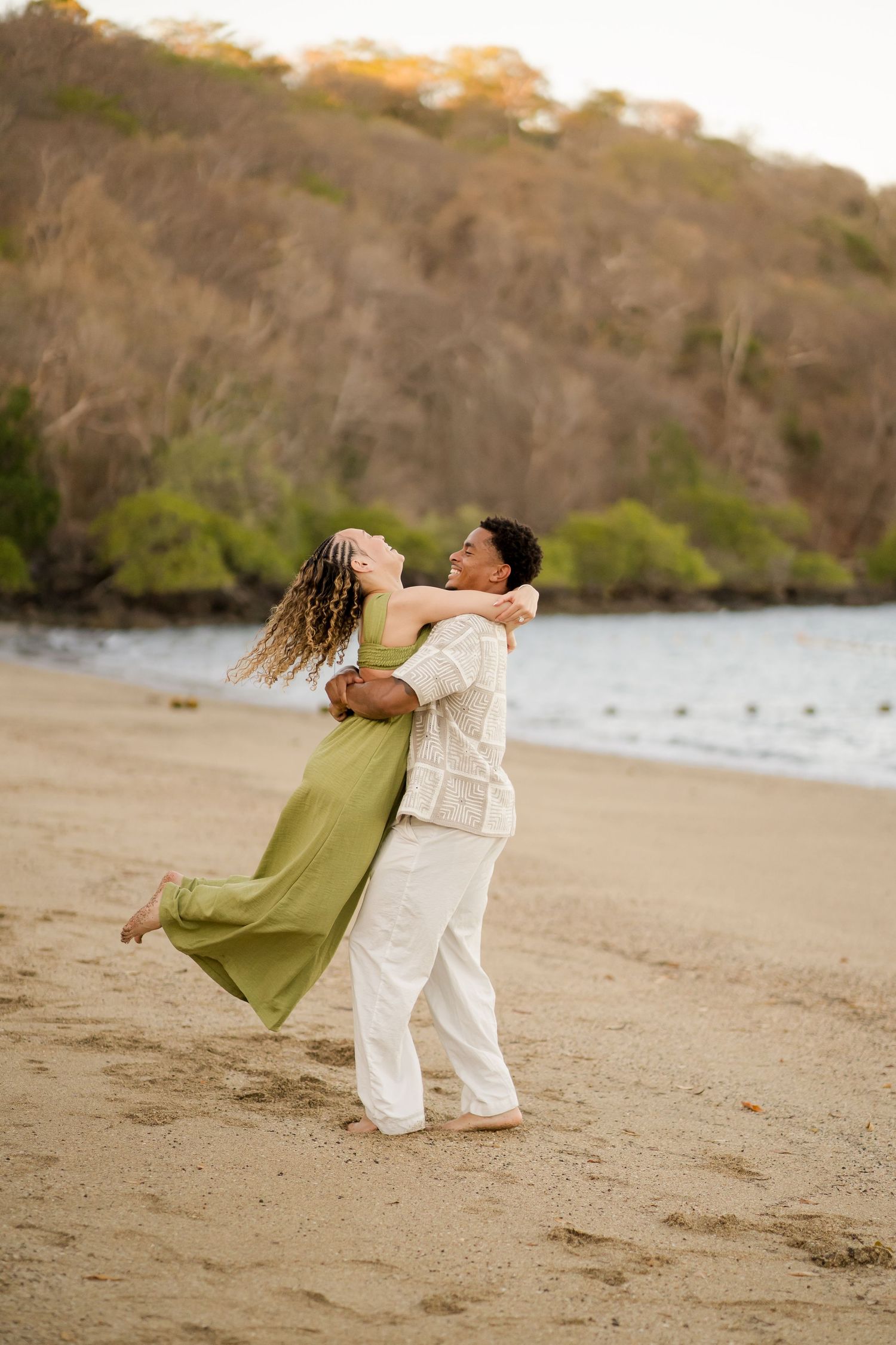 Engaged couple celebrating together on the beach at Andaz Peninsula Papagayo in Costa Rica.