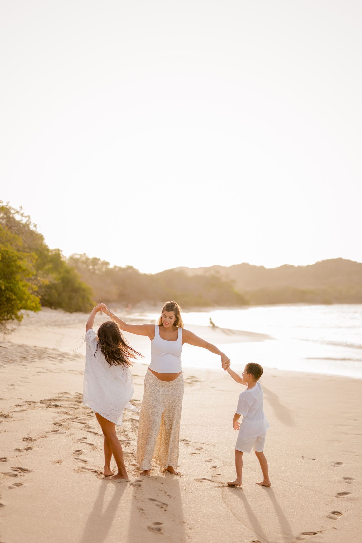 Expecting mother with children together by the ocean during a maternity photography session at Playa Conchal.