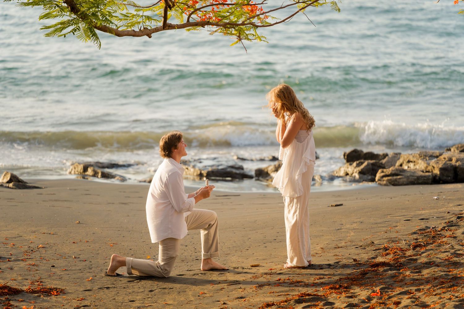 Man proposing on one knee during a romantic beach engagement session at Playa Ocotal, Costa Rica.