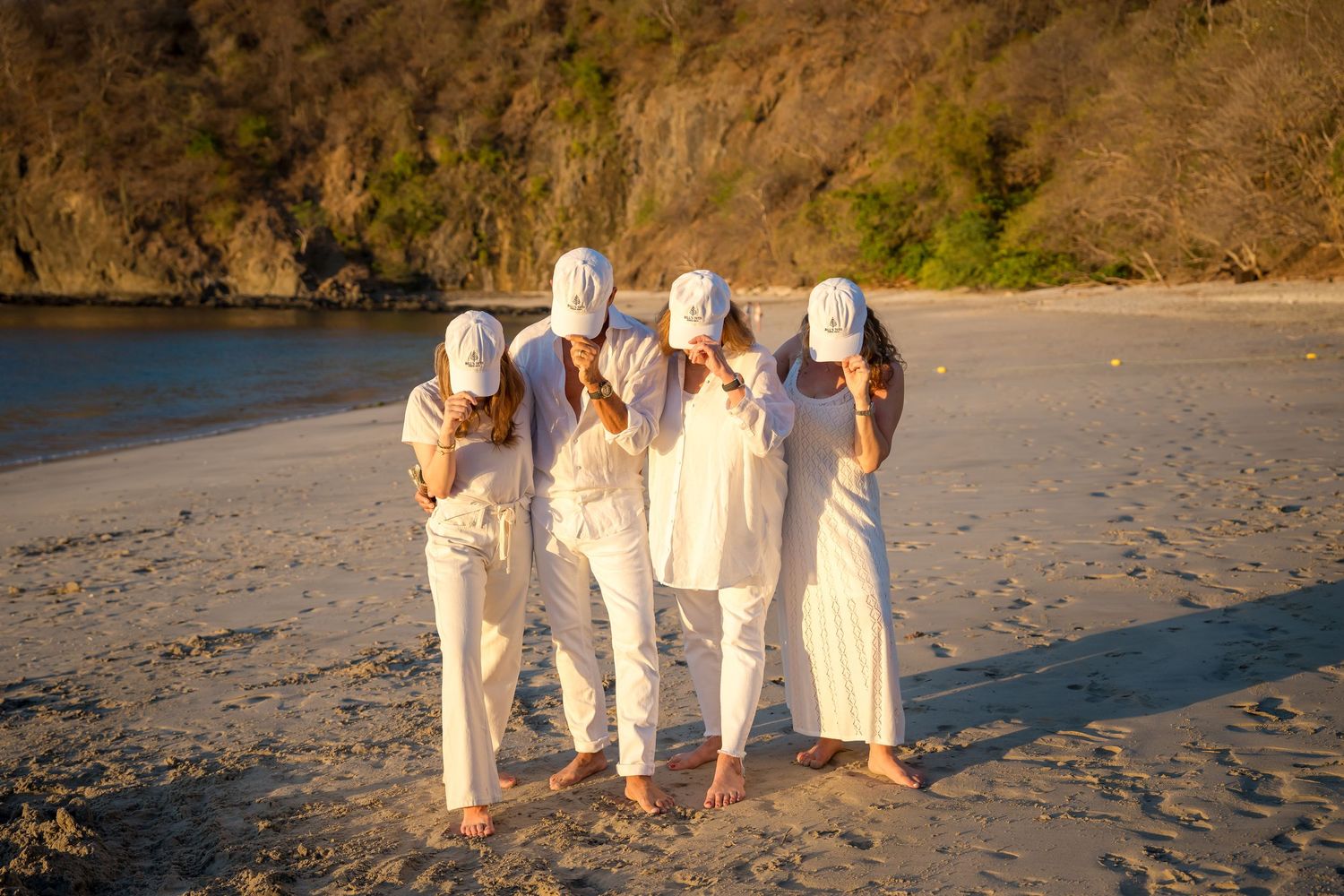 Family walking together on the beach at sunset during a photography session at Four Seasons Papagayo, Costa Rica.