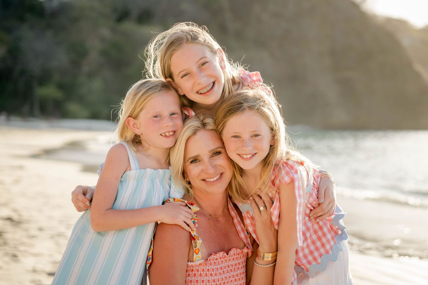 Mother and daughters smiling together during a family beach photography session in Costa Rica.