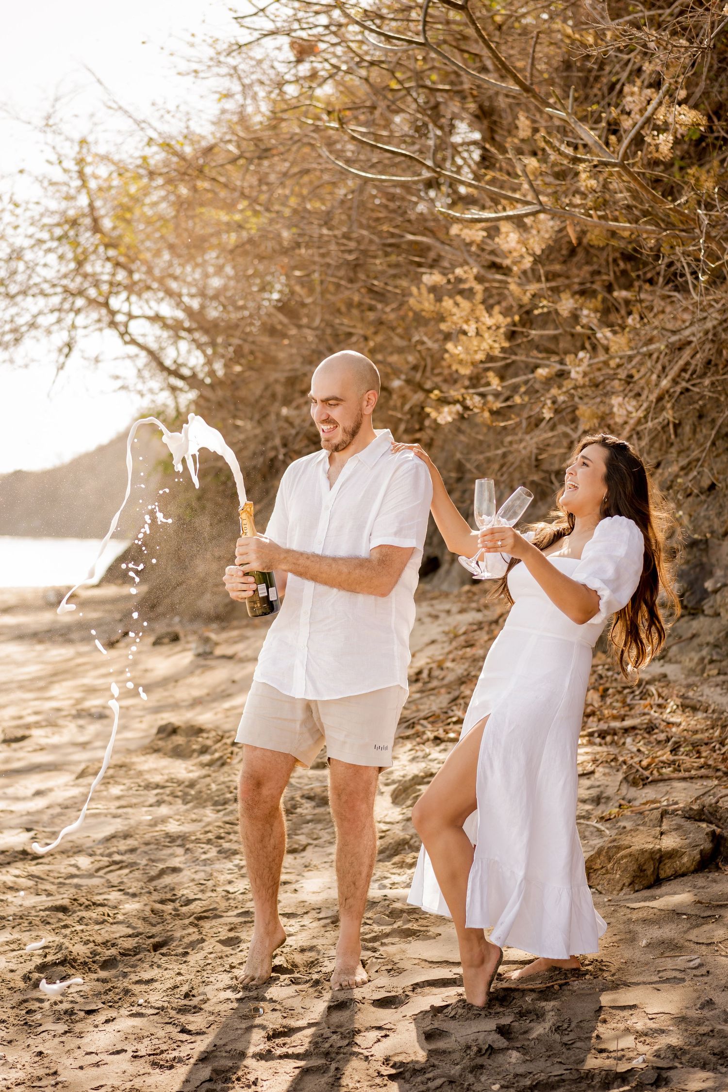 Couple enjoying a playful beach photography session at El Mangroove in Playa Panamá, Guanacaste, Costa Rica.