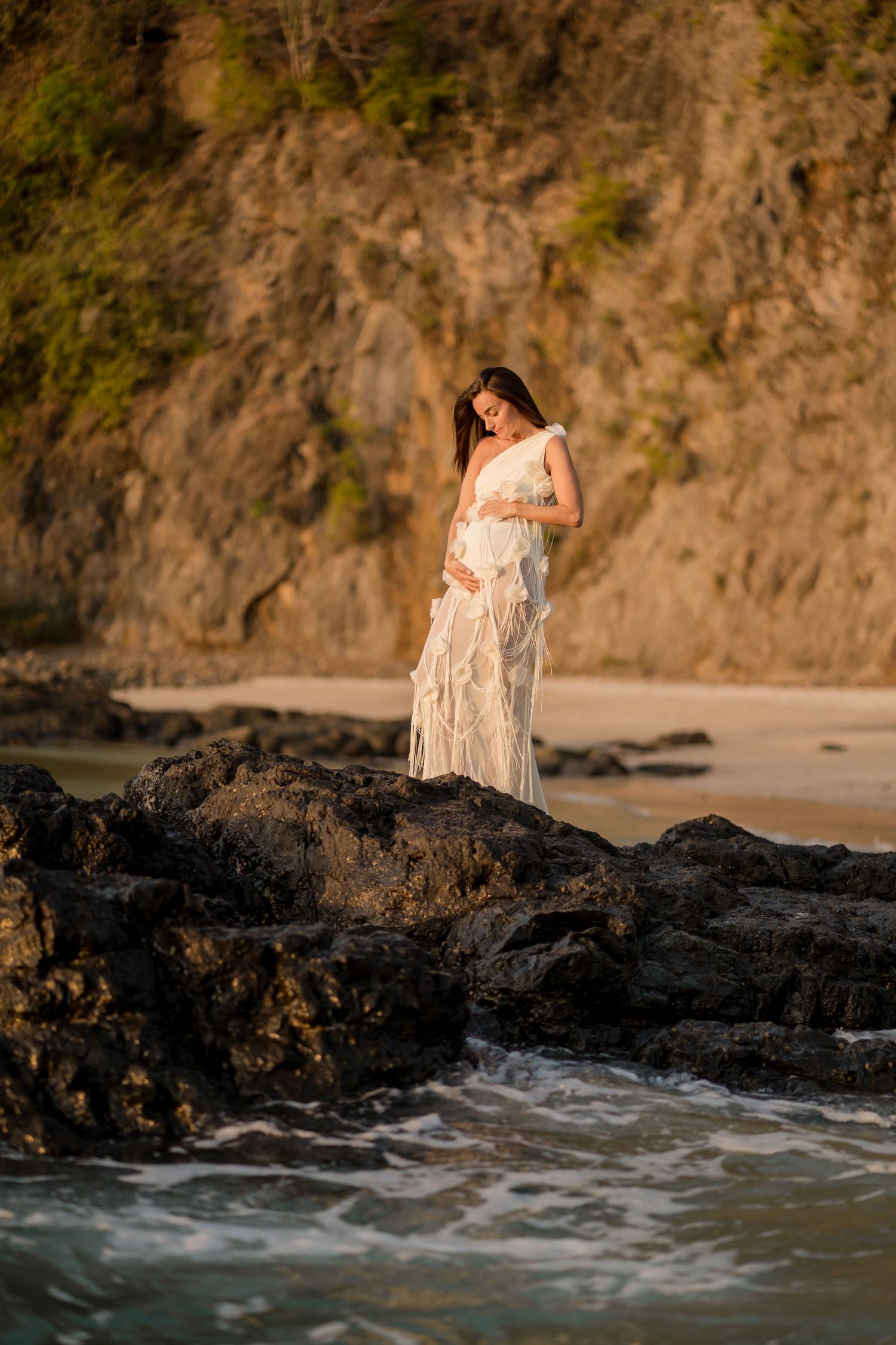 Expecting mother posing by the ocean during a maternity photography session in Costa Rica.