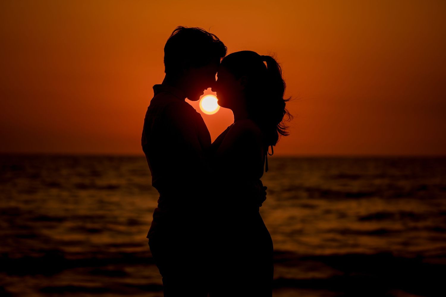 Romantic silhouette of a couple kissing at sunset during a beach photography session in Las Catalinas, Costa Rica.