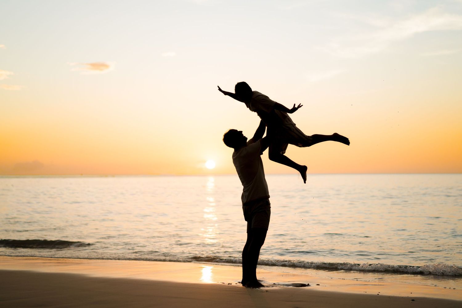 Father lifting his daughter at sunset during a family photography session at Four Seasons Costa Rica at Peninsula Papagayo.