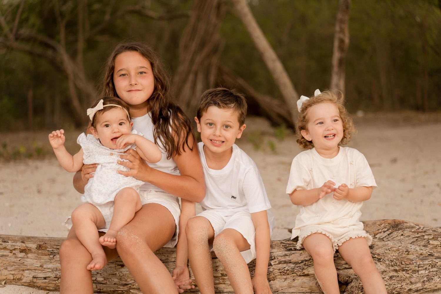 Young cousins sitting together on the sand during their Playa Conchal family photography session.