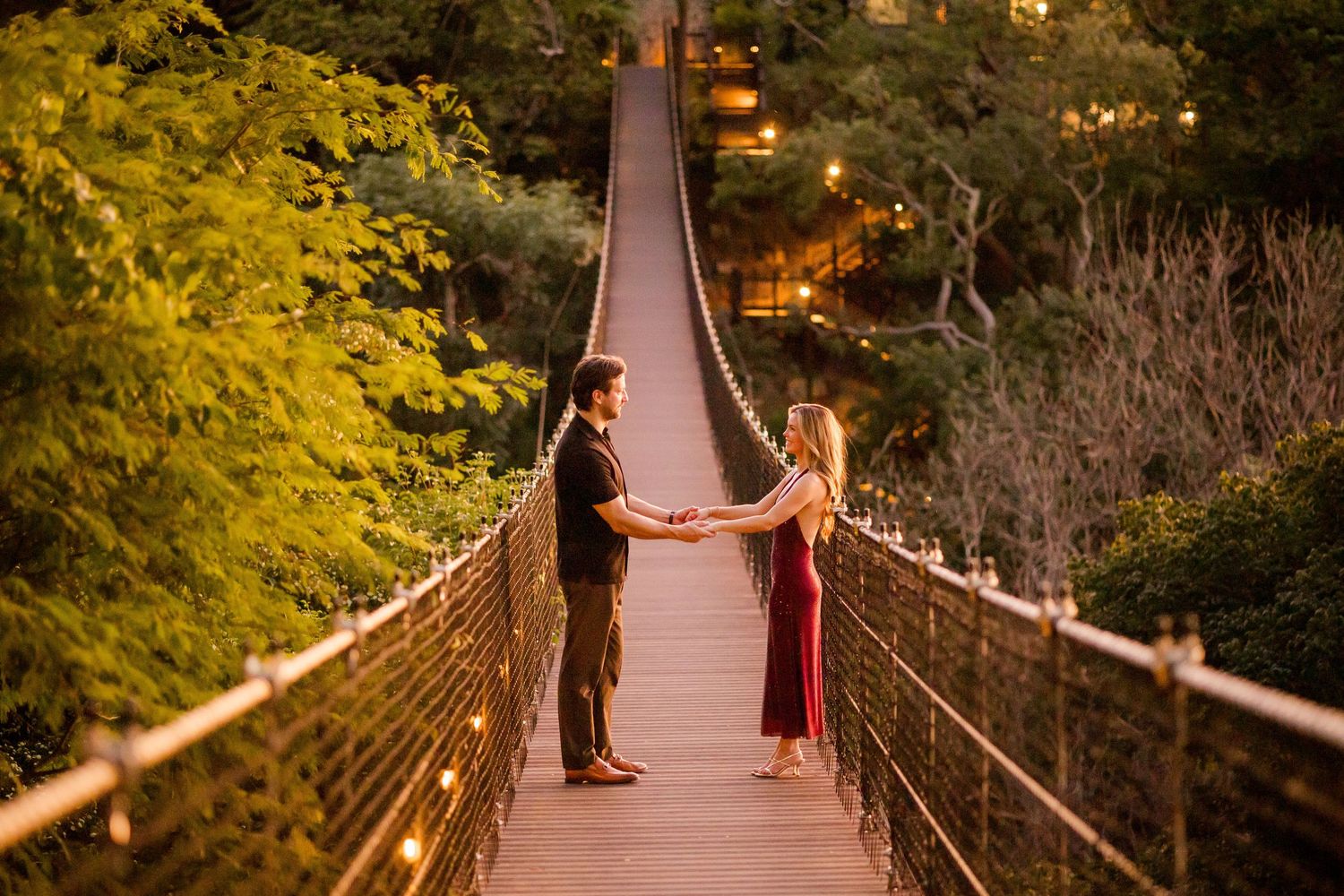 Couple walking hand in hand across a suspension bridge during their Nekajui engagement photography session
