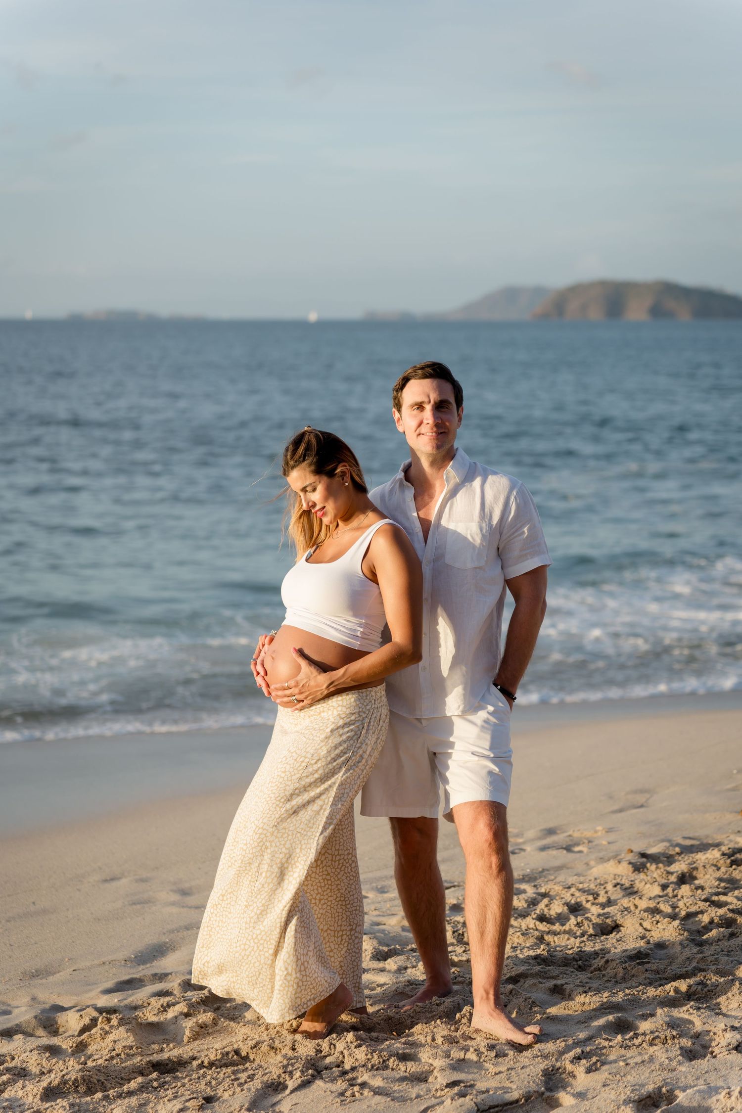 Expecting couple sharing an affectionate moment during their maternity session near Reserva Conchal.
