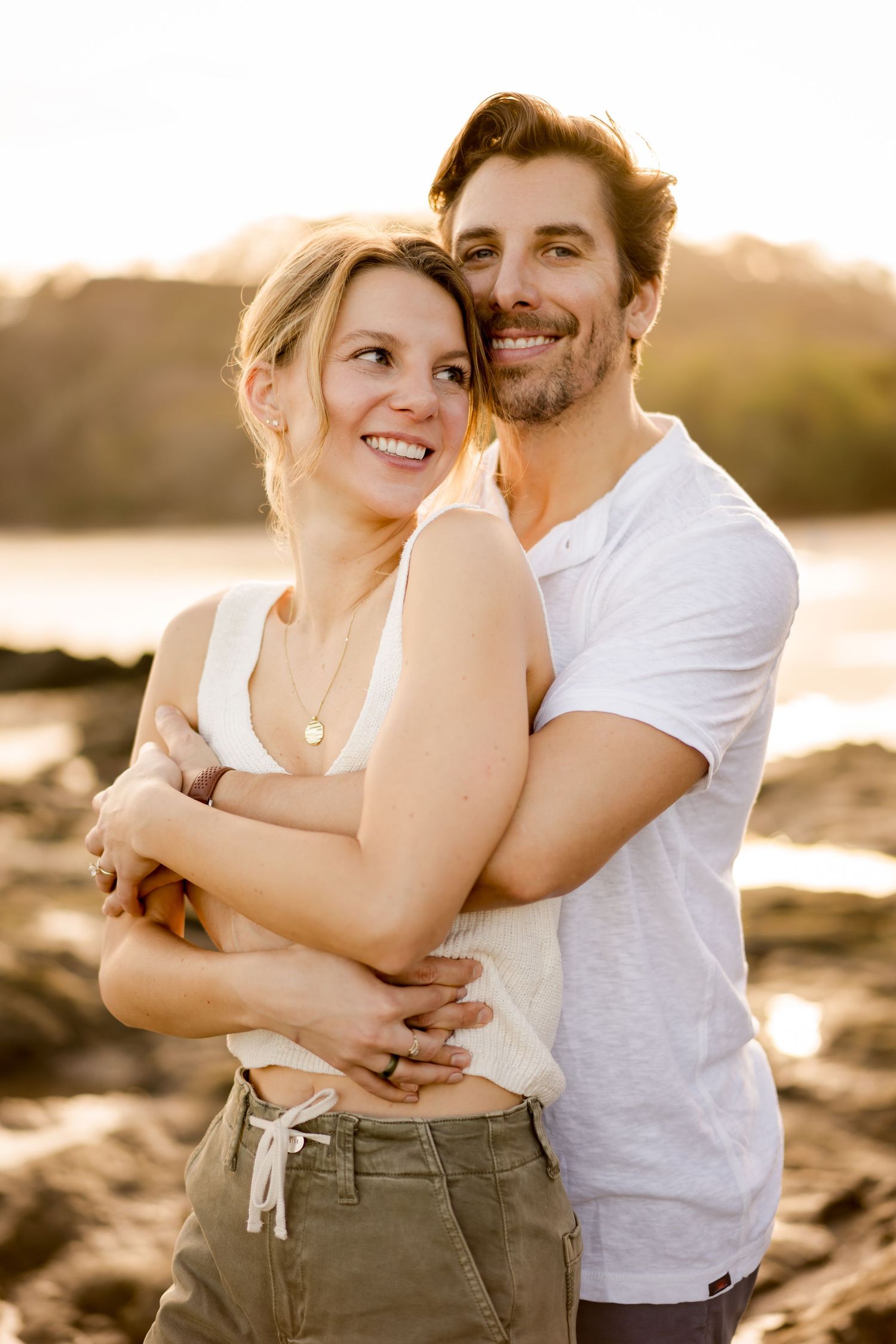 Couple laughing and embracing during a golden hour photography session at Playa Hermosa in Guanacaste, Costa Rica.