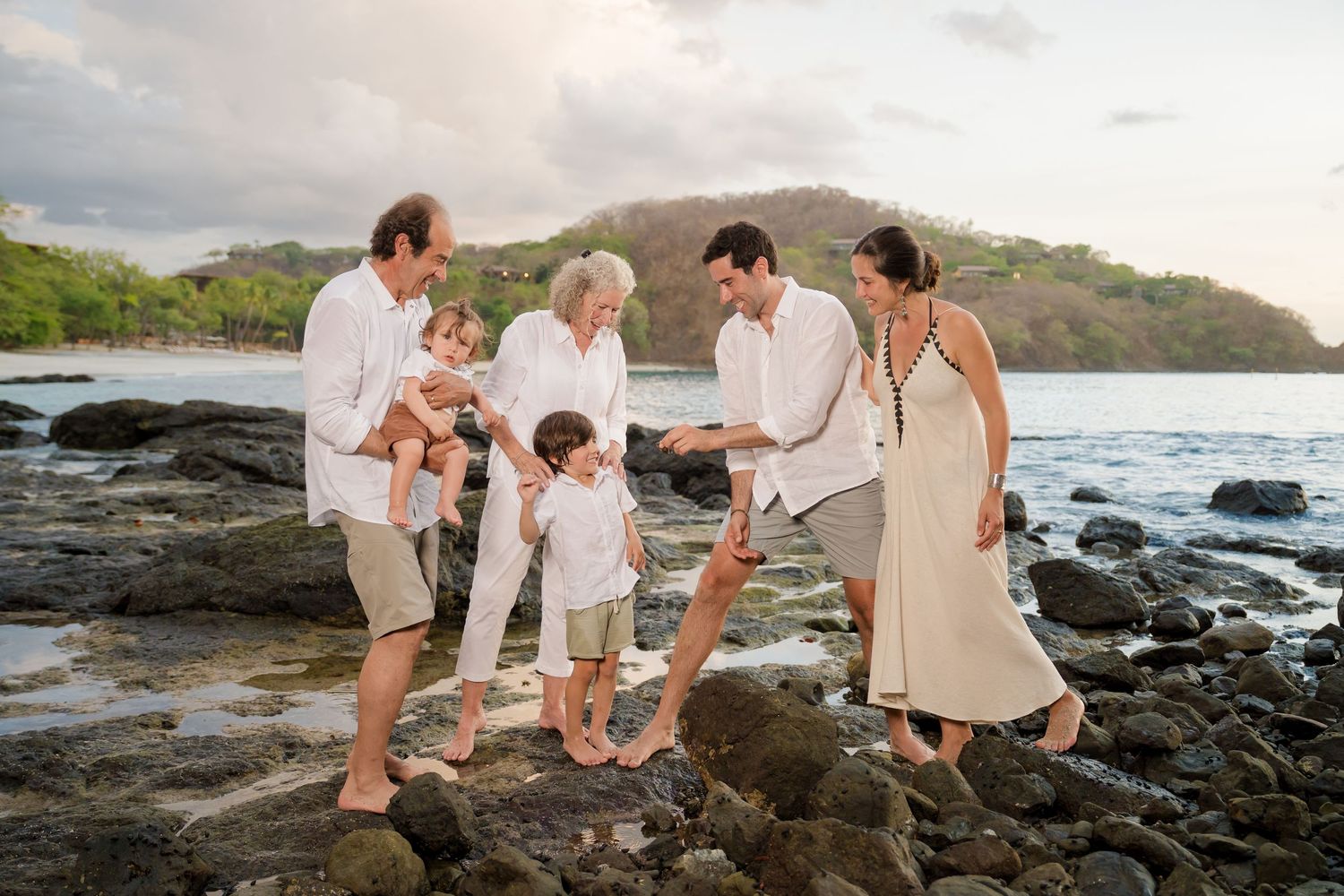 Multi-generational family enjoying the rocky shoreline during a family photography session at Four Seasons Peninsula Papagayo, Costa Rica.