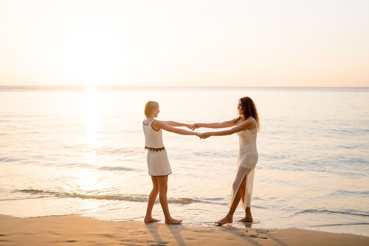 Mother and daughter holding hands on the beach at sunset during a family photography session in Peninsula Papagayo, Costa Rica.