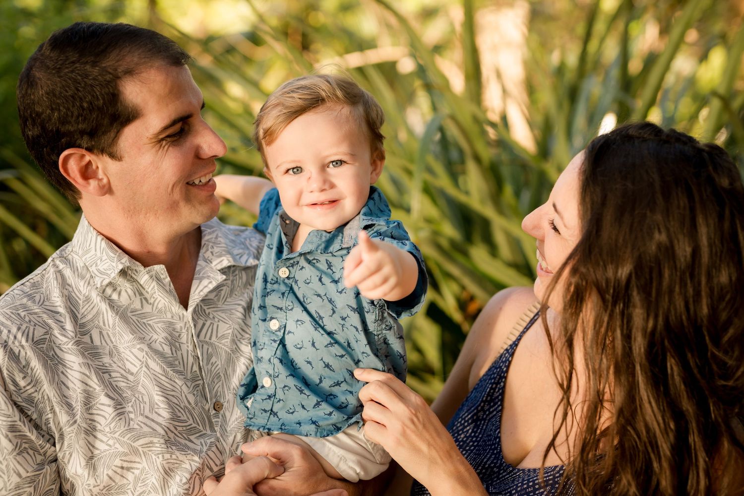 Parents smiling with their young child during a relaxed family vacation photography session in Costa Rica.