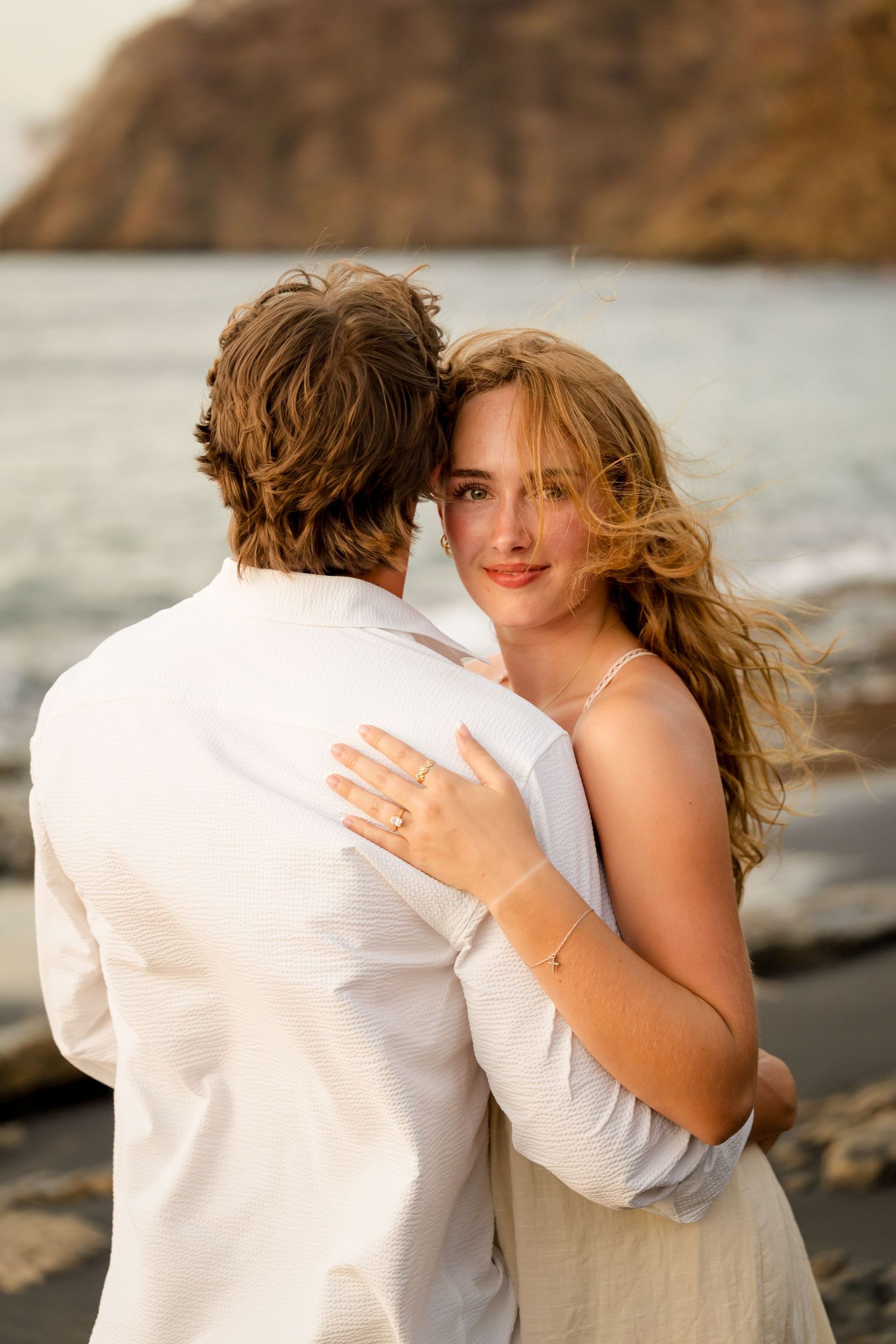 Engaged couple embracing by the ocean during a romantic photography session at Playa Ocotal in Guanacaste, Costa Rica.