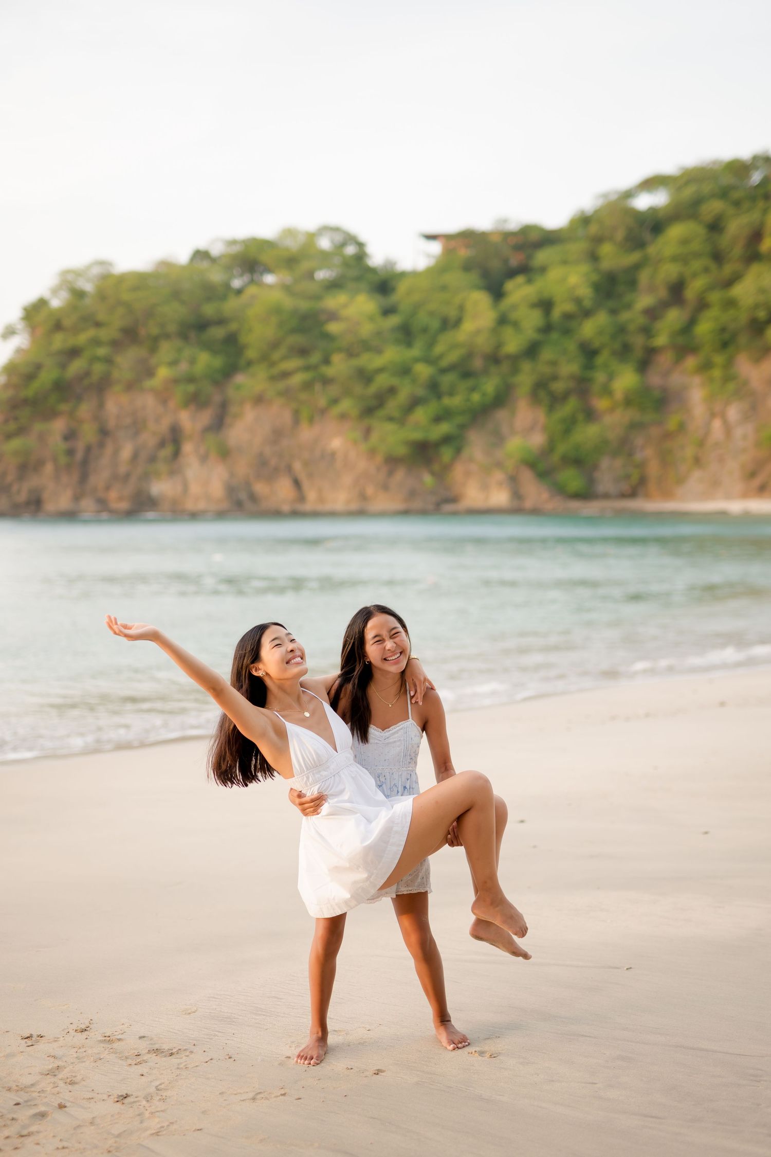 Sisters playing together on the beach during a family photography session at Four Seasons Peninsula Papagayo, Costa Rica.