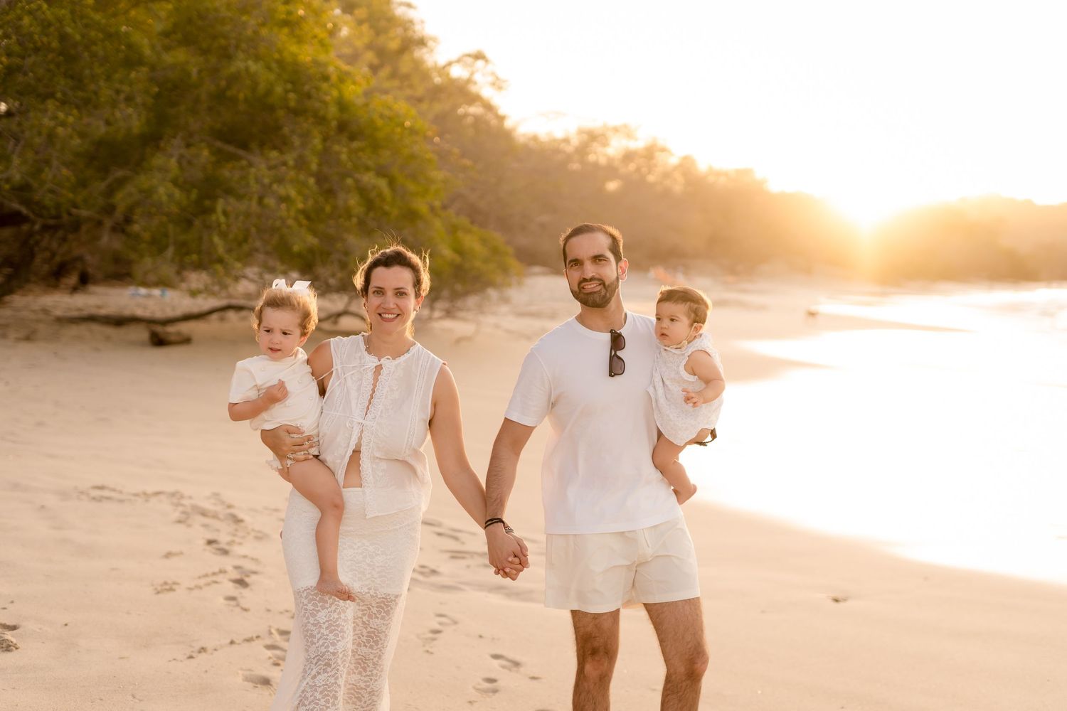 Happy family sharing a playful moment during their beach photography session at Playa Conchal.